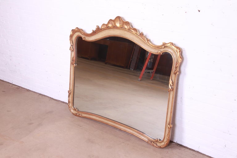 A gorgeous French Rococo style large wall mirror with gold gilt and painted wood frame

By John Widdicomb

USA, Circa 1940s

Measures: 52.25