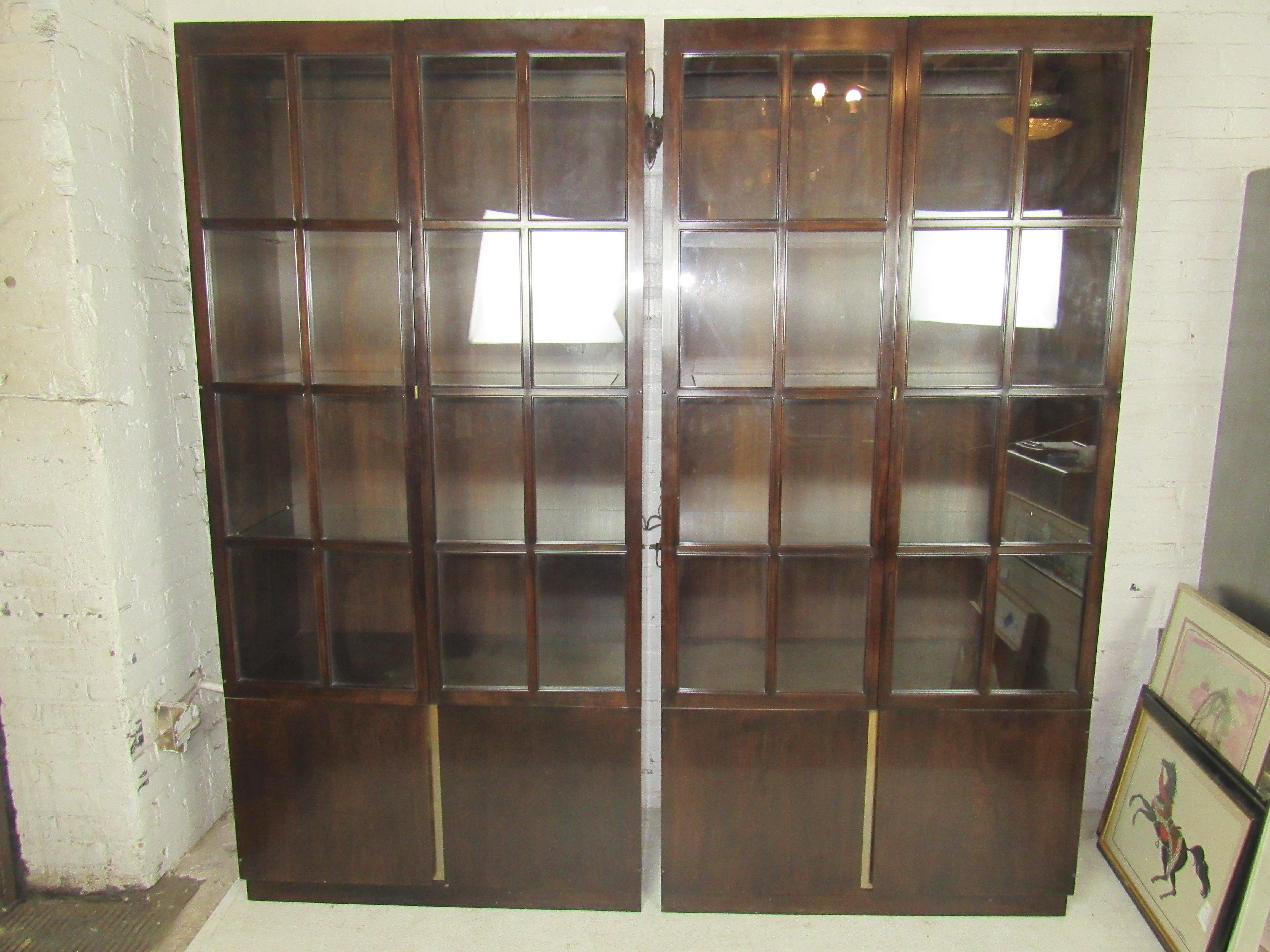 Mid-Century Modern mahogany bookcases with glass front doors and glass shelves. Lighting inside, storage cabinet below.
Price is for single unit.
(Please confirm item location - NY or NJ - with dealer).
  