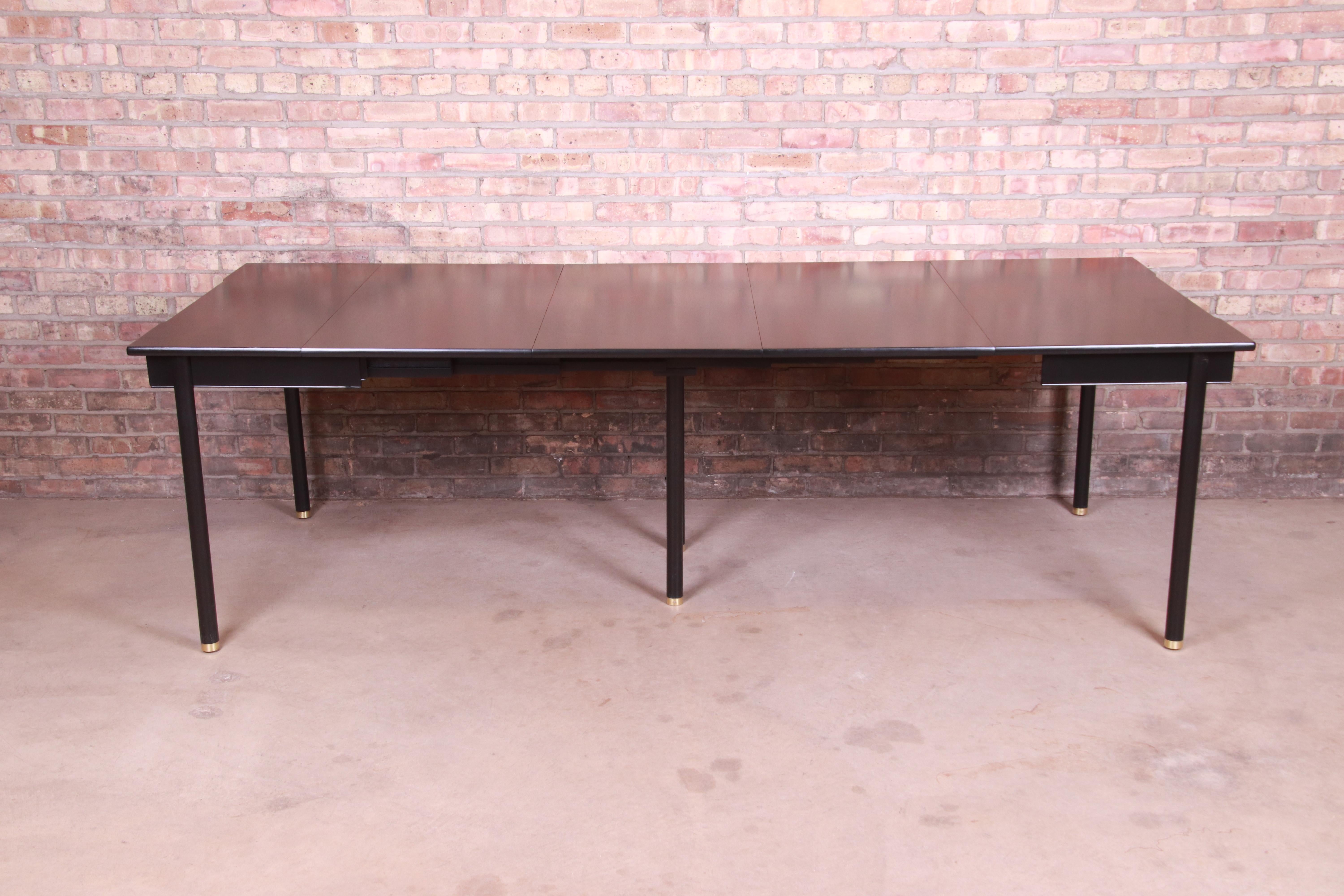 An exceptional Mid-Century Modern Hollywood Regency extension dining table

By John Widdicomb,

USA, 1950s

Black lacquered cherry wood, with brass-capped feet.

Measures: 97