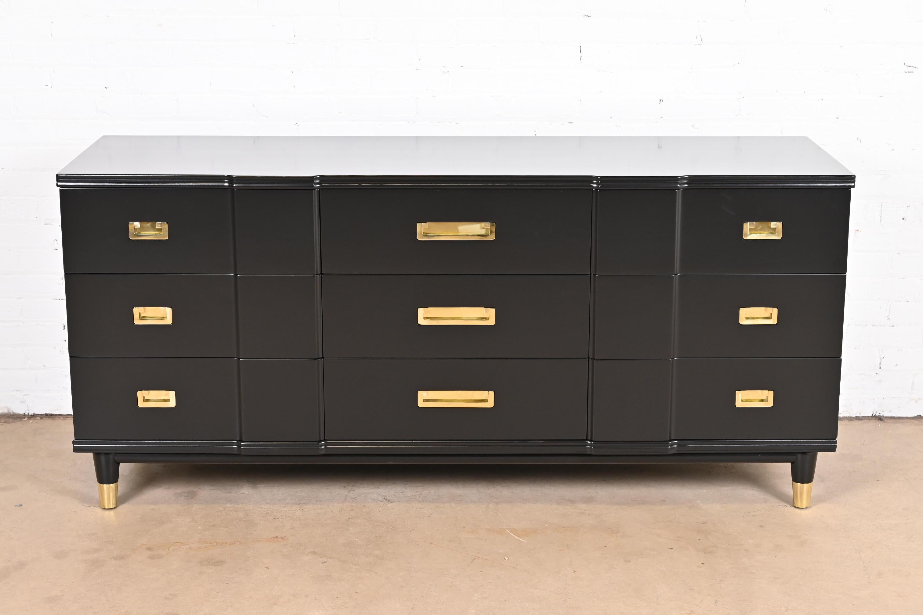 An exceptional mid-century modern Hollywood Regency Campaign nine-drawer long dresser or credenza

By John Widdicomb

USA, 1950s

Black lacquered solid cherry wood, with original brass hardware and brass-capped feet.

Measures: 70.25