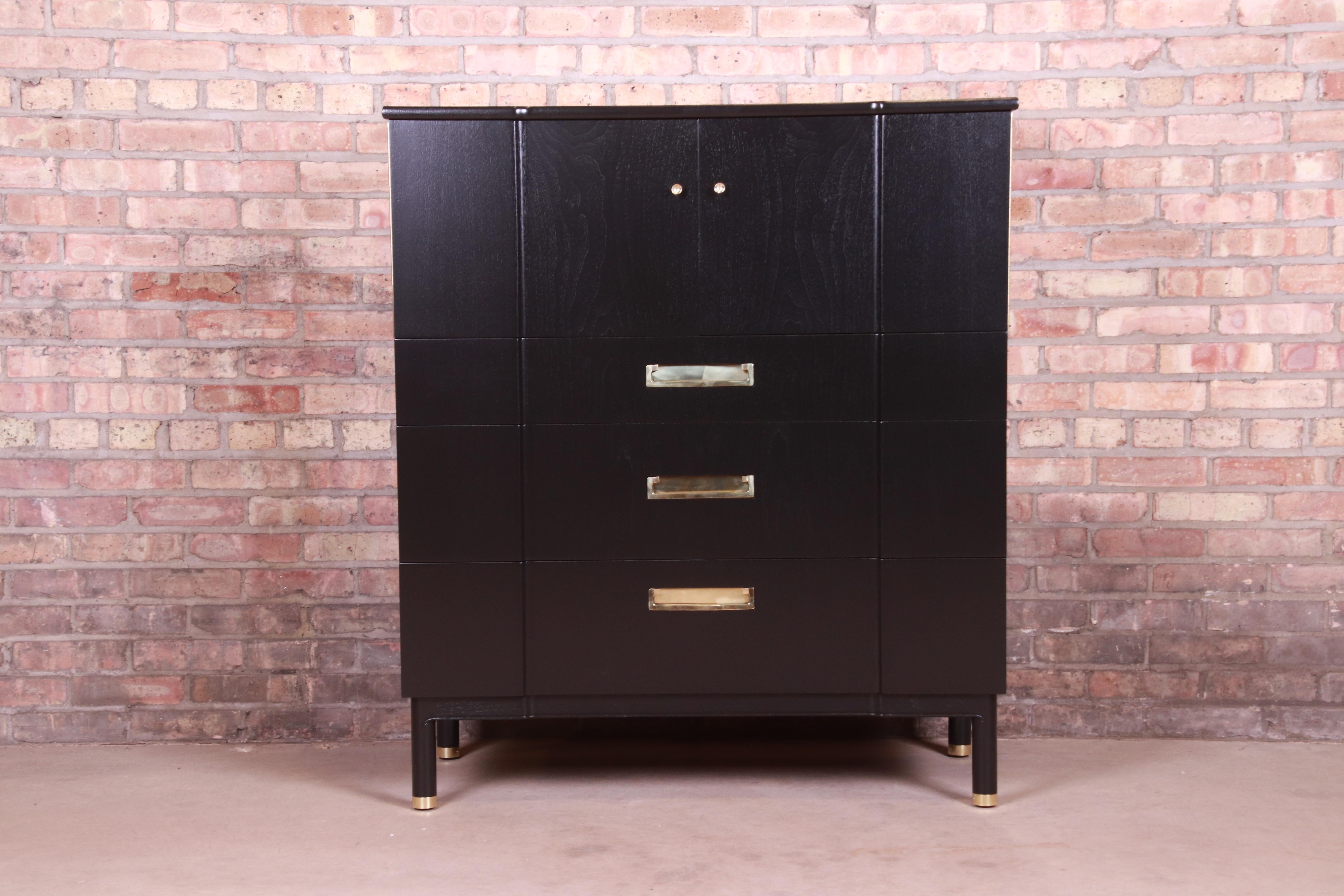 An exceptional Mid-Century Modern Hollywood Regency Campaign style highboy dresser or gentleman's chest

By John Widdicomb,

USA, 1950s

Black lacquered solid cherry wood, with original brass hardware and brass-capped feet.

Measures: 40.5