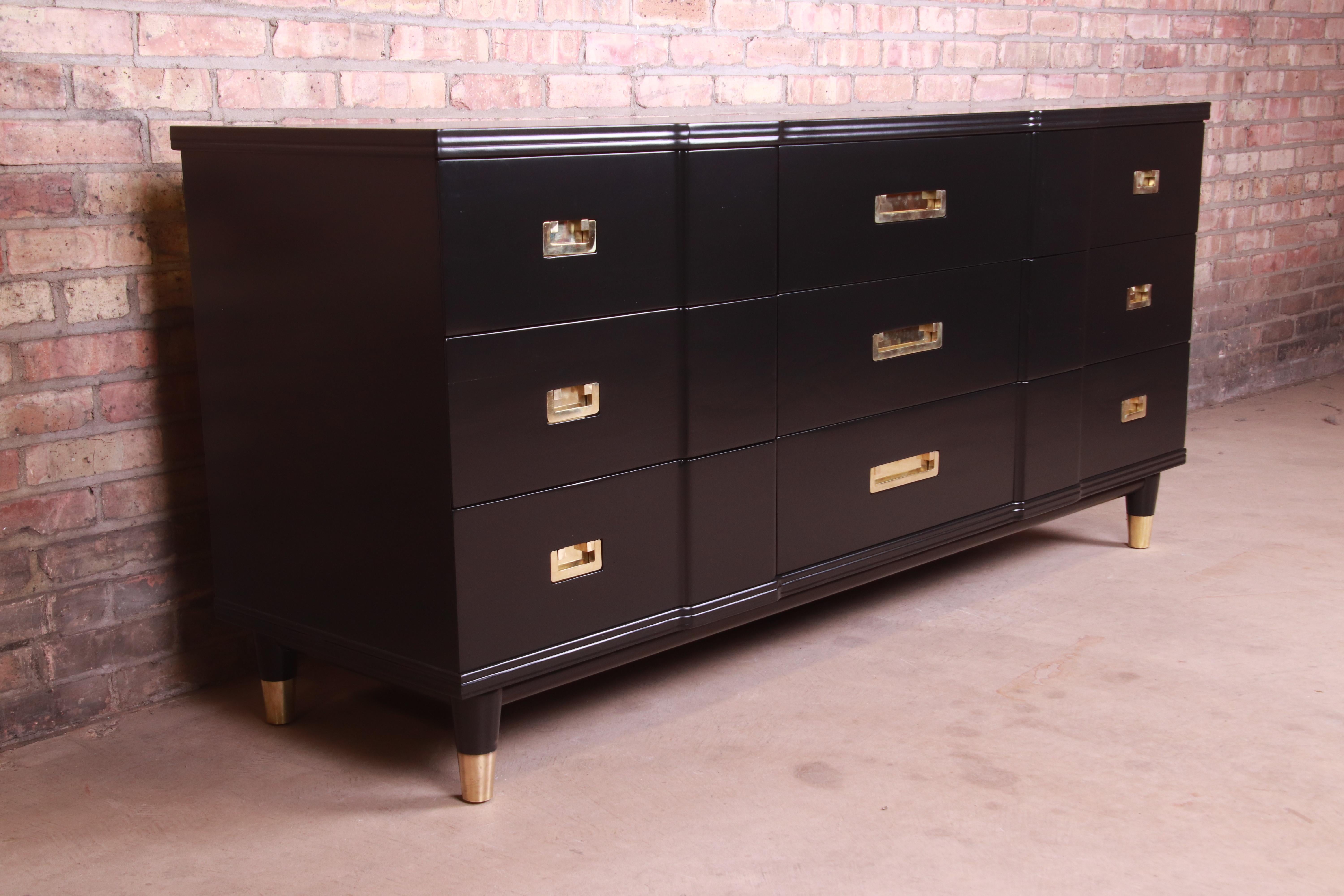 An exceptional Mid-Century Modern Hollywood Regency Campaign nine-drawer long dresser or credenza

By John Widdicomb

USA, 1950s

Black lacquered solid cherry wood, with original brass hardware and brass-capped feet.

Measures: 70.25