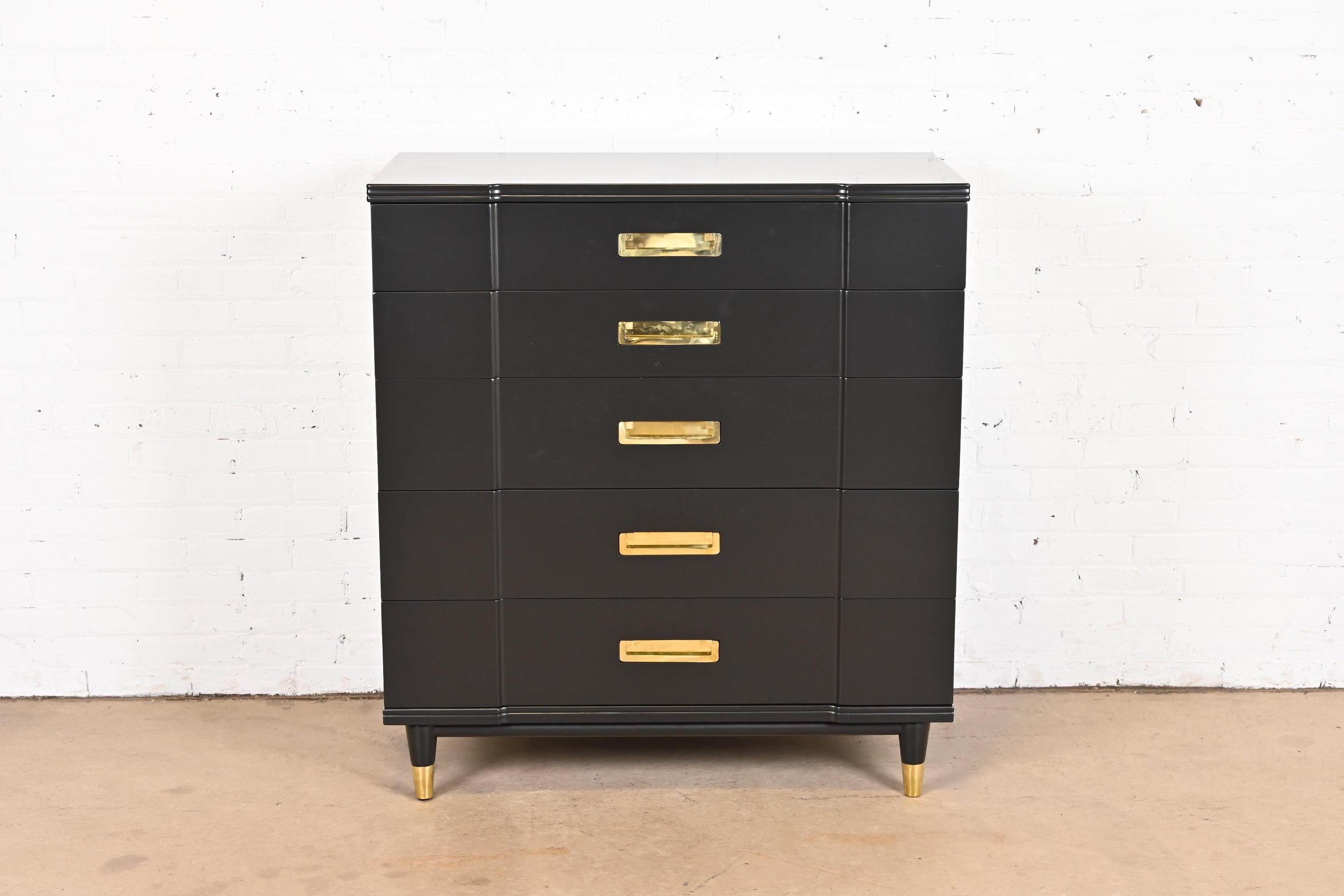An exceptional mid-century modern Hollywood Regency Campaign five-drawer highboy dresser

By John Widdicomb

USA, 1950s

Black lacquered solid cherry wood, with original brass hardware and brass-capped feet.

Measures: 40.25