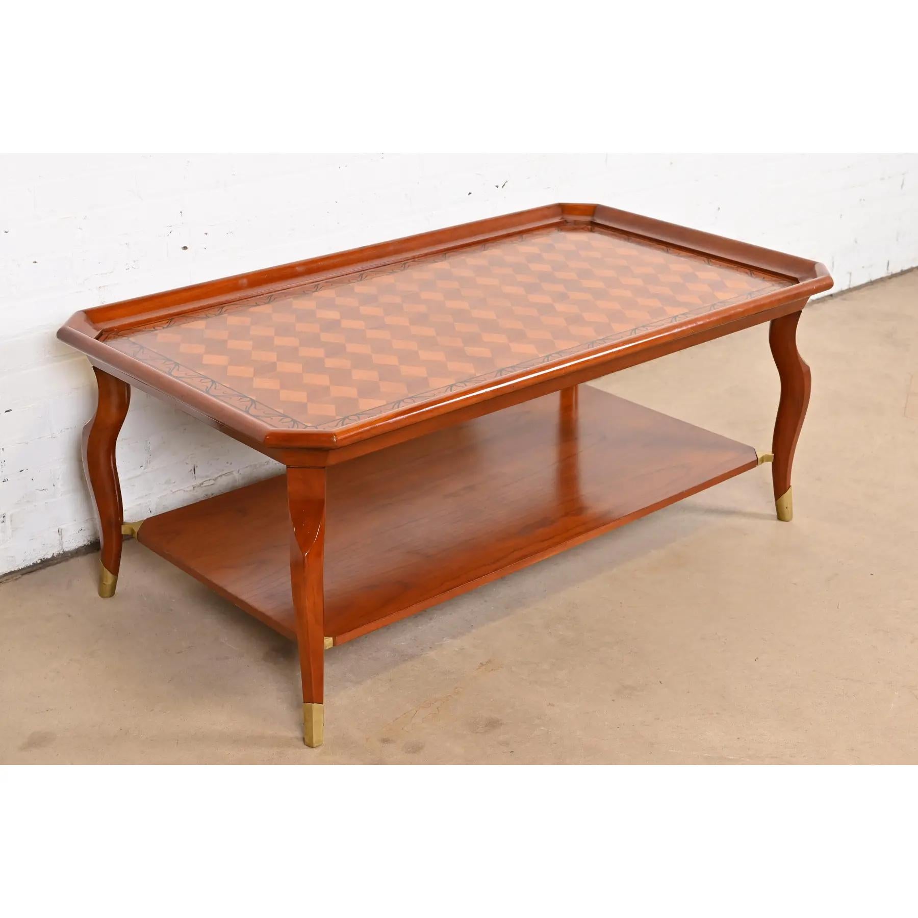 Magnifique table basse ou table de cocktail à deux niveaux de style provincial italien

Par John Widdicomb

États-Unis, fin du 20e siècle

Acajou, avec parquet en bois satiné incrusté, et sabots en laiton.

Dimensions : 54 