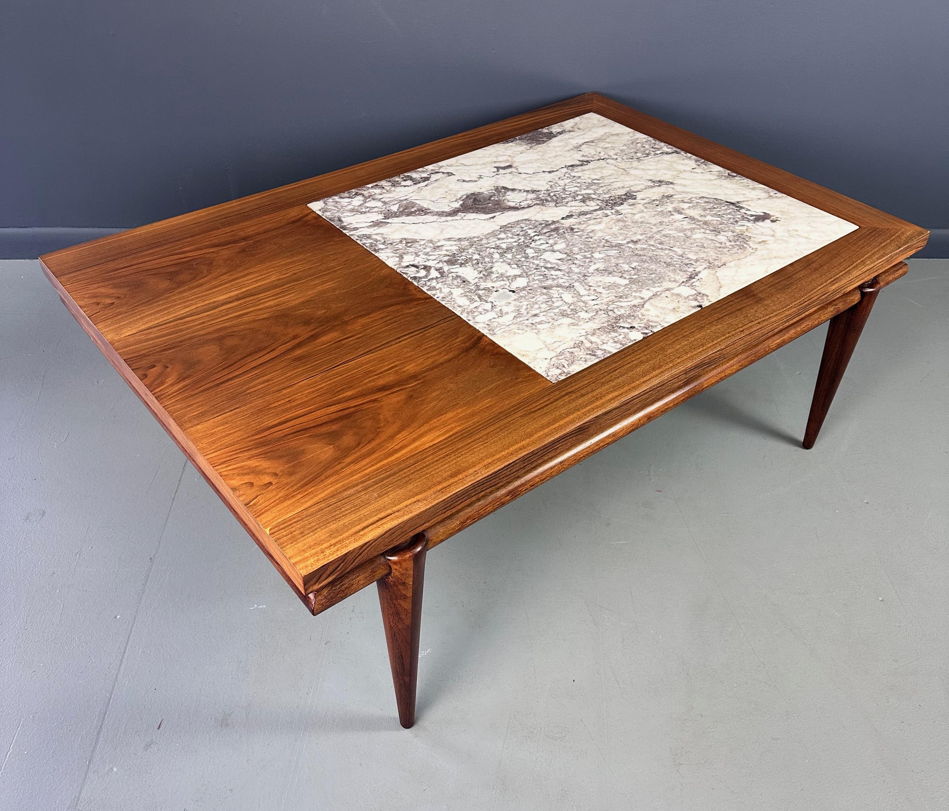 Crafted with elegant marble and rich walnut, the John Widdicomb Coffee Table brings sophisticated style to any living space. Inspired by the iconic designs of Robsjohn Gibbings, this piece oozes class and luxury. Elevate your home decor with this