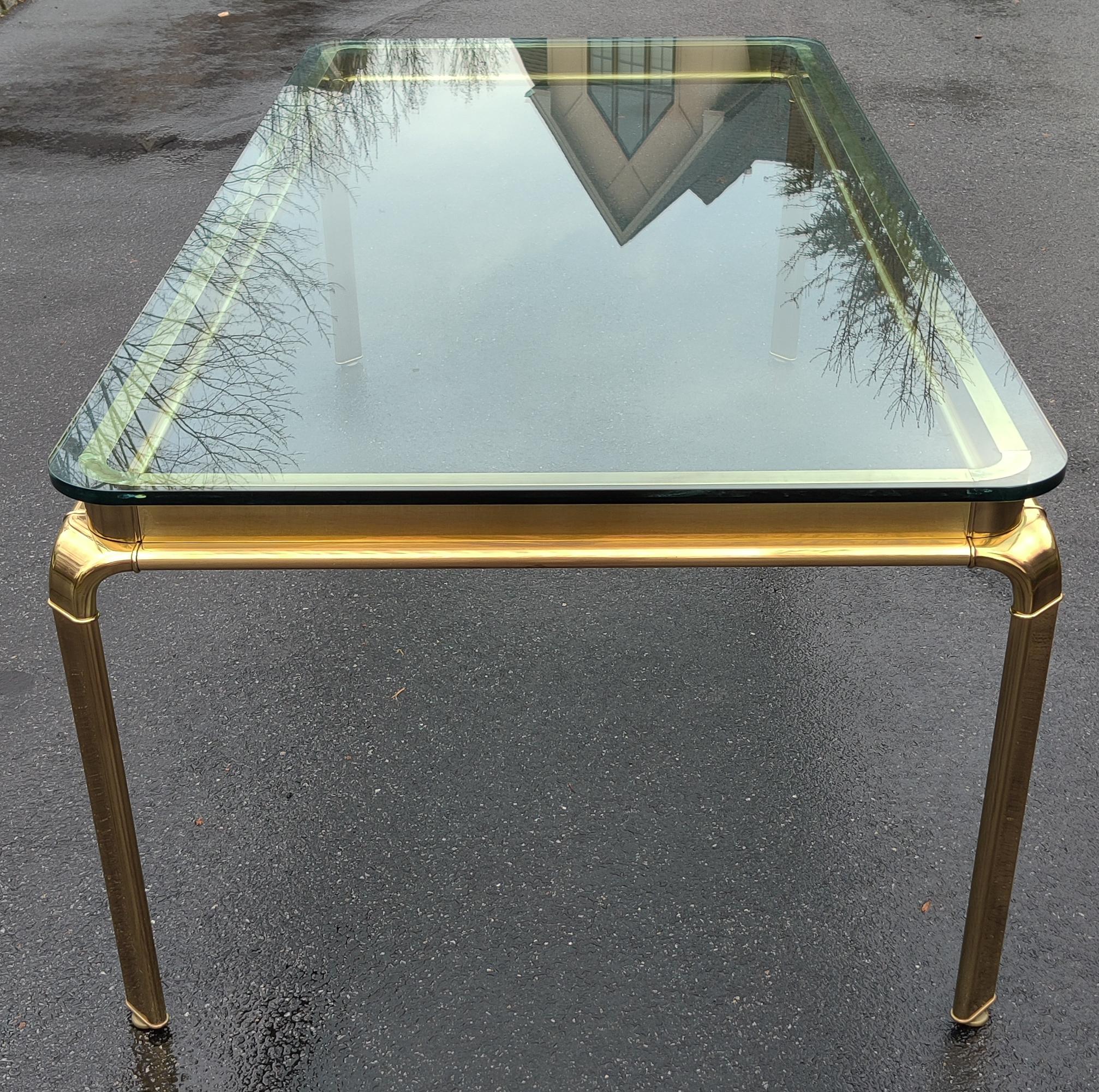 This is a premium, heirloom quality, plate-glass and antiqued-brass dining table by John Widdicomb. It is very large at nearly 90 inches long. Very heavy, and certainly imposing. The glass top is approximately 1 inch thick. The heavy and supremely