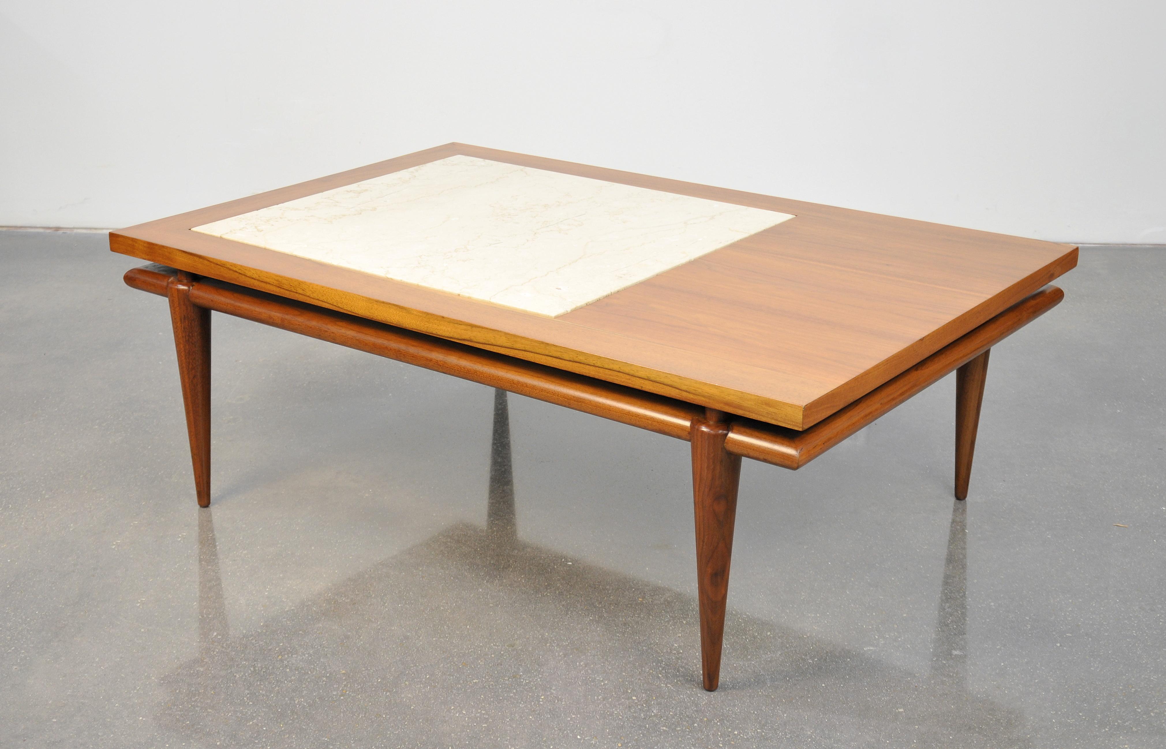 A gorgeous vintage set of Mid-Century Modern tables, including a cocktail and an end table, by John Widdicomb, dating from the 1960s. The coffee table features a rectangular top with inset Italian travertine marble floating over a base with tapering