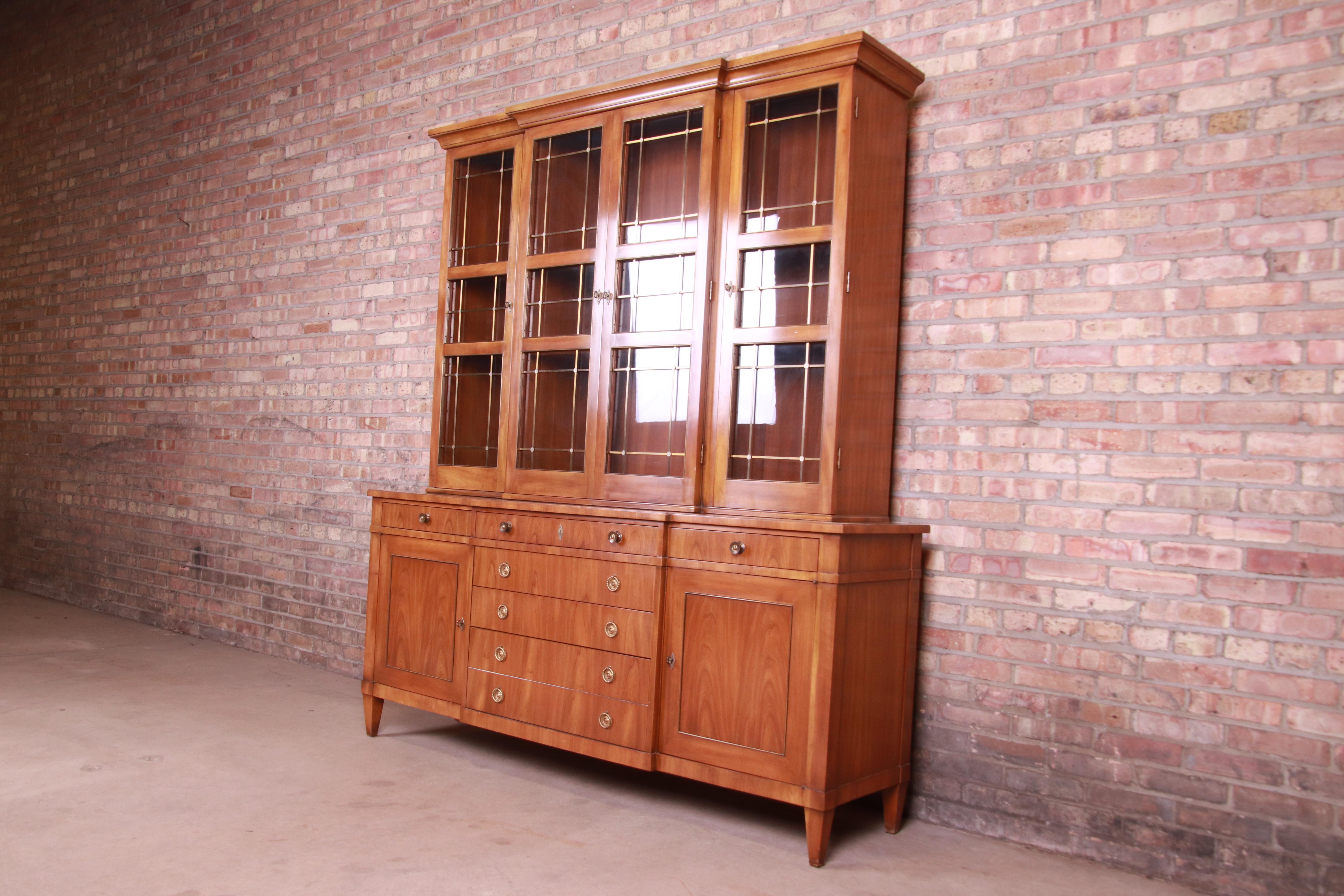 A gorgeous mid-century French Regency style sideboard credenza with glass front display cabinet or bookcase

By John Widdicomb,

USA, 1950s

Book-matched cherry wood, with mullioned glass front doors and brass hardware and
