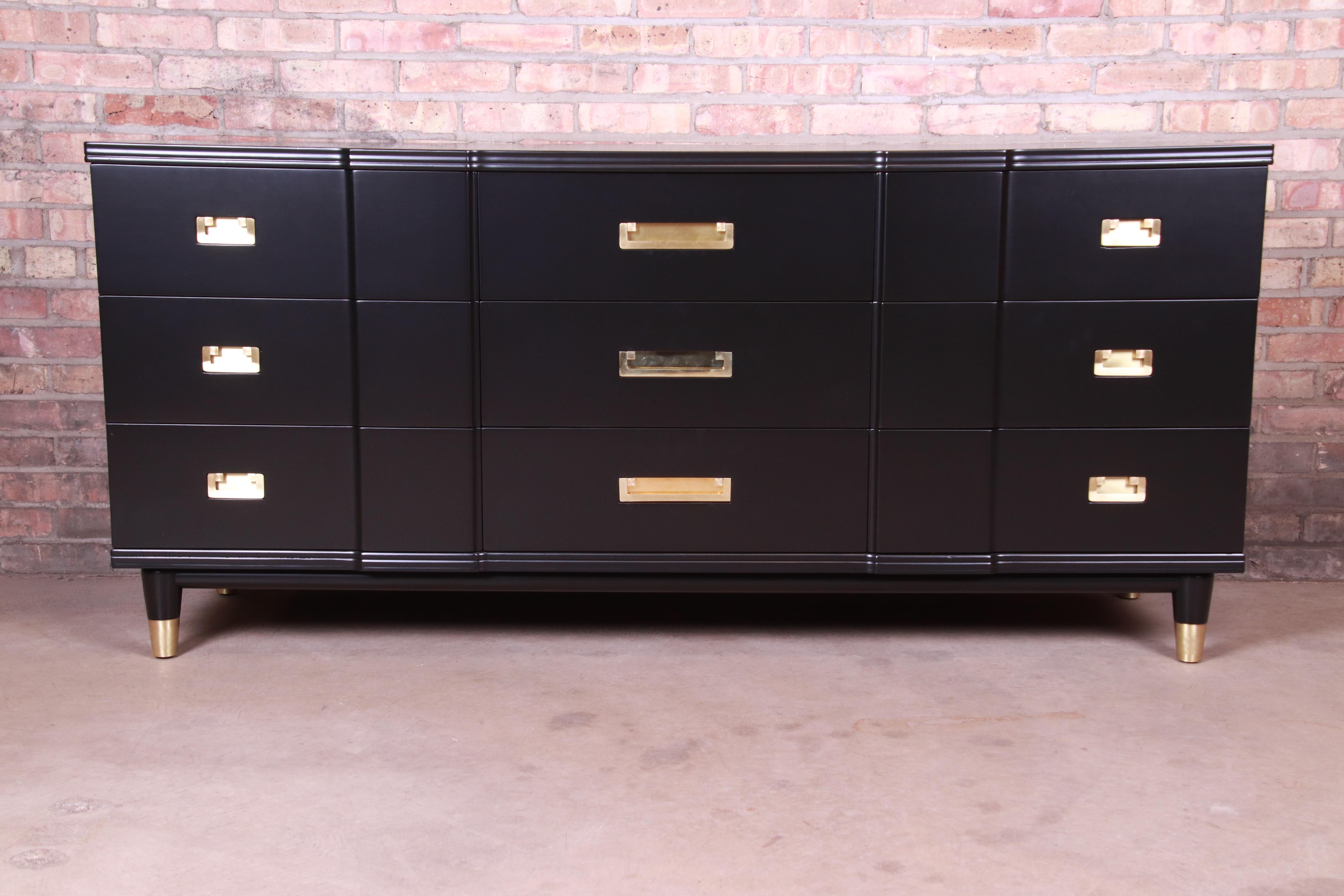 An exceptional Mid-Century Modern Hollywood Regency Campaign nine-drawer long dresser or credenza

By John Widdicomb

USA, 1950s

Black lacquered solid cherrywood, with original brass hardware and brass-capped feet.

Measures: 70.25