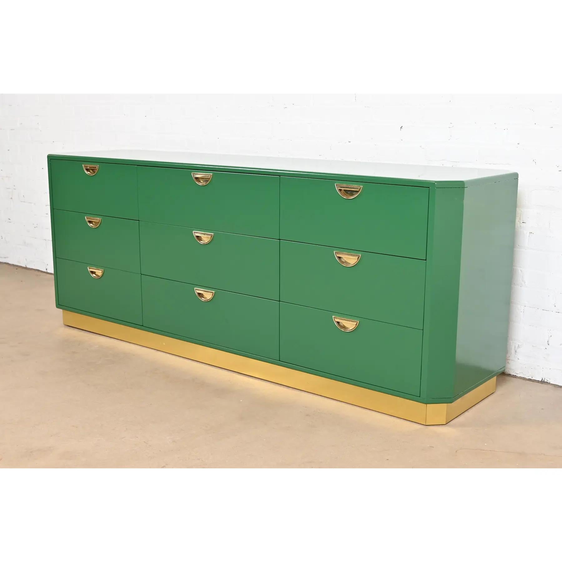 An exceptional mid-century modern Hollywood Regency Campaign triple dresser or credenza

By John Widdicomb

USA, Circa 1970s

Green lacquered walnut, with original brass hardware., and brass plinth base.

Measures: 76.75
