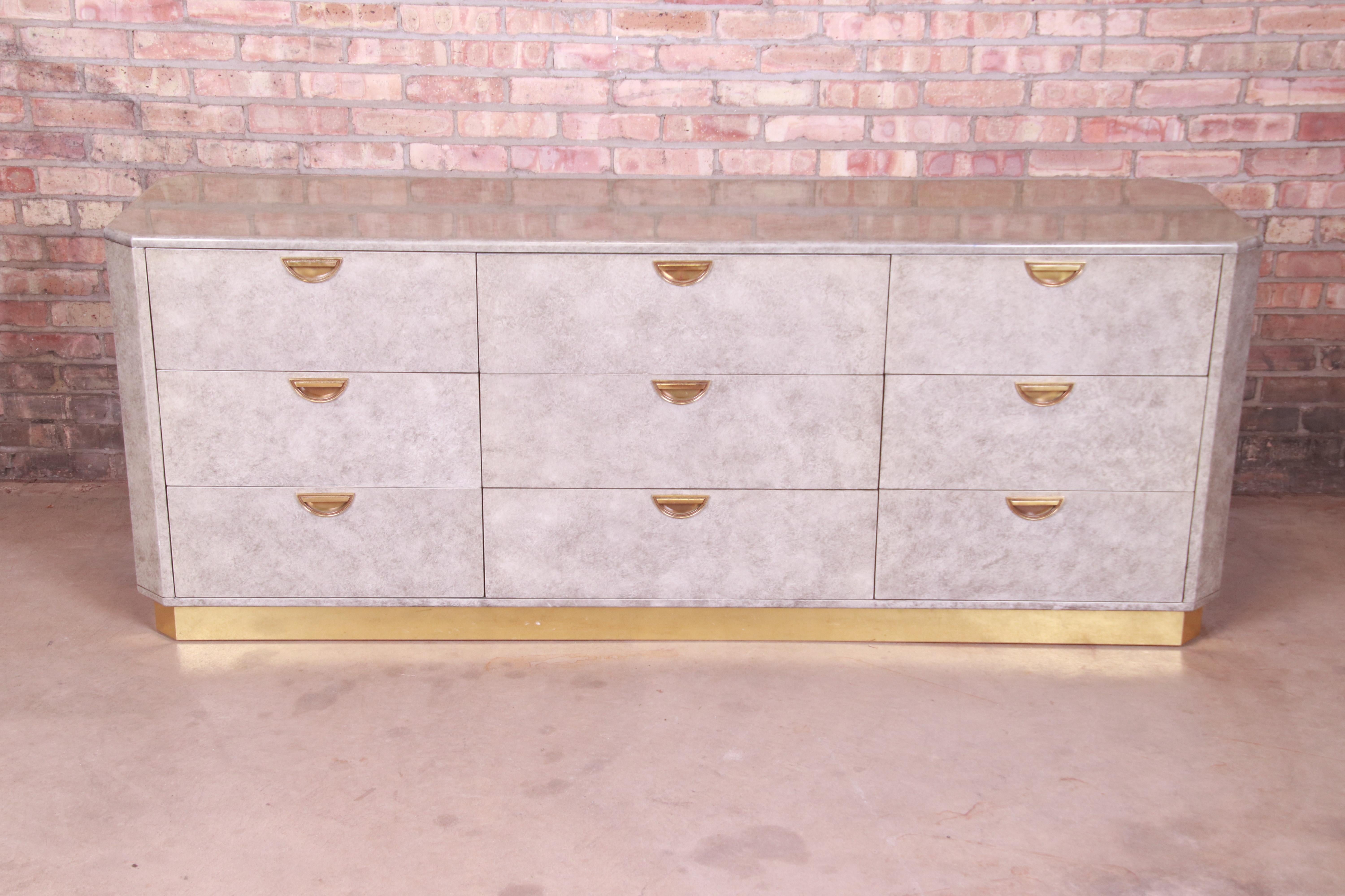 An exceptional Mid-Century Modern Hollywood Regency triple dresser or credenza

By John Widdicomb

USA, circa 1970s

Wood construction with lacquered faux marble finish in a grayish green, original brass hardware, and brass plinth
