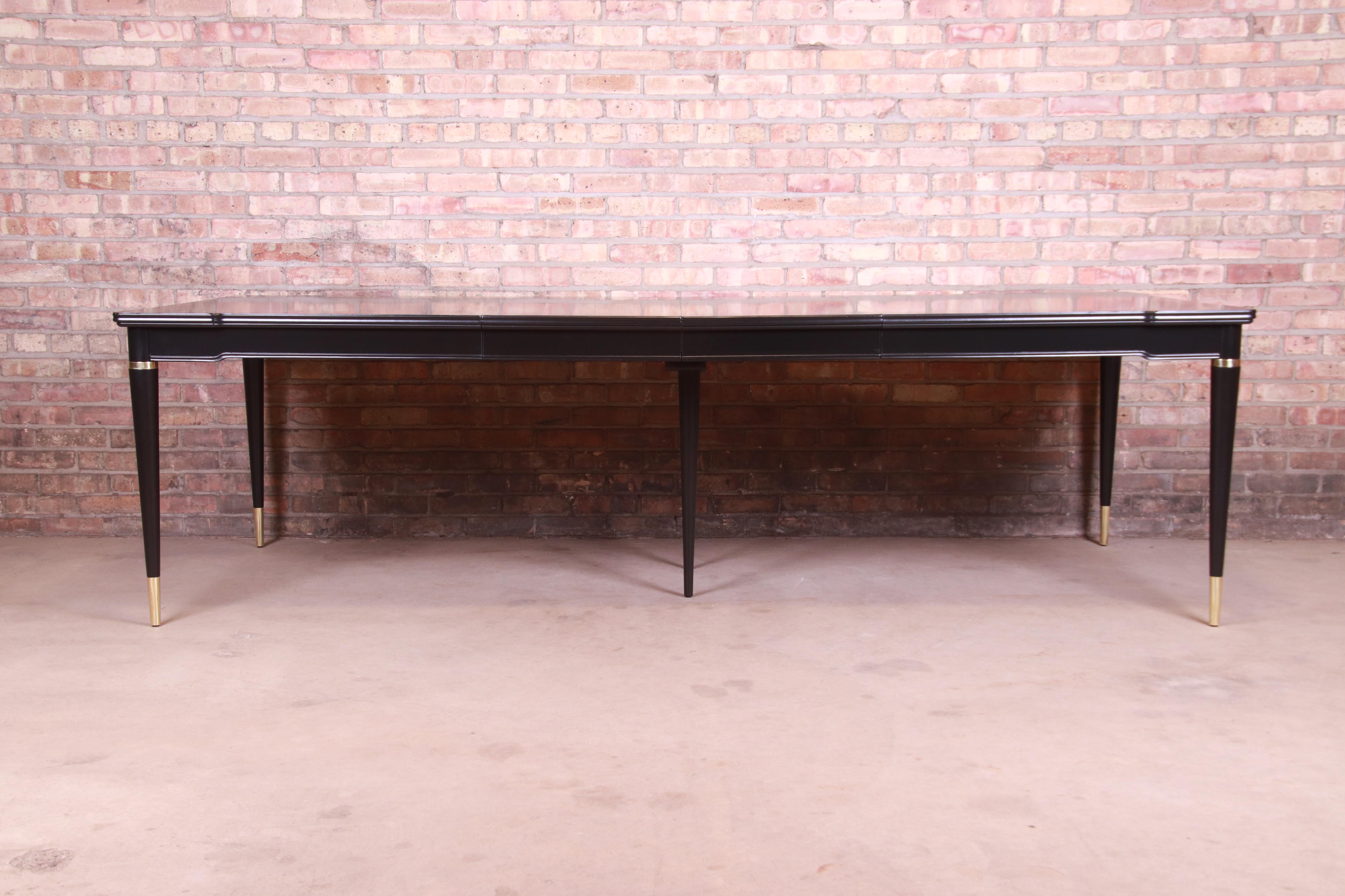 An exceptional mid-century modern Hollywood Regency extension dining table

By John Widdicomb,

USA, 1950s

Black lacquered cherry wood, with brass accents and brass-capped feet.

Measures: 66