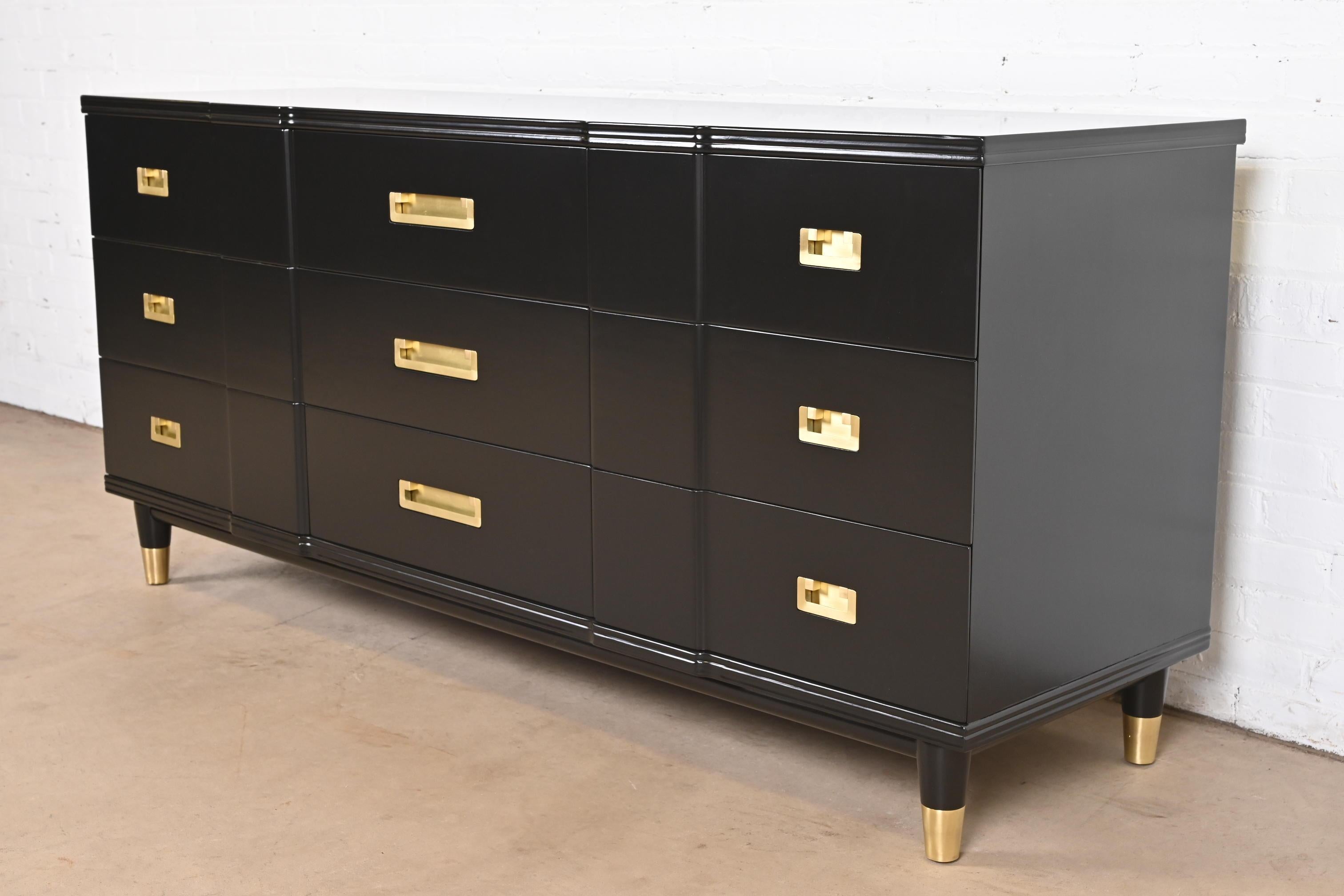 An exceptional mid-century modern Hollywood Regency Campaign nine-drawer long dresser or credenza

By John Widdicomb

USA, 1950s

Black lacquered solid cherry wood, with original brass hardware and brass-capped feet.

Measures: 70.25