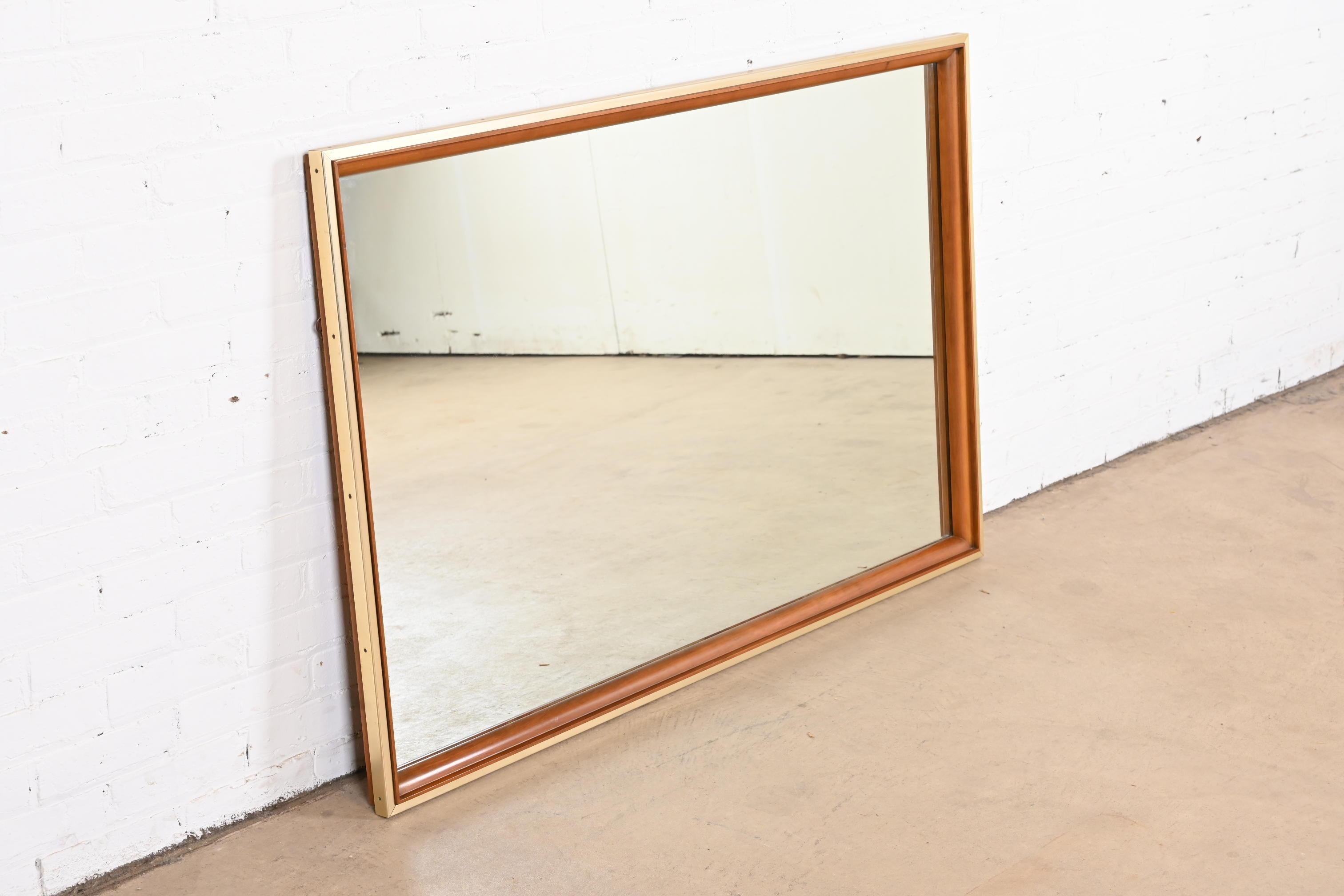 A gorgeous Mid-Century Modern large framed wall mirror

By John Widdicomb

USA, 1950s

Solid cherry wood, with brass trim.

Measures: 52.38