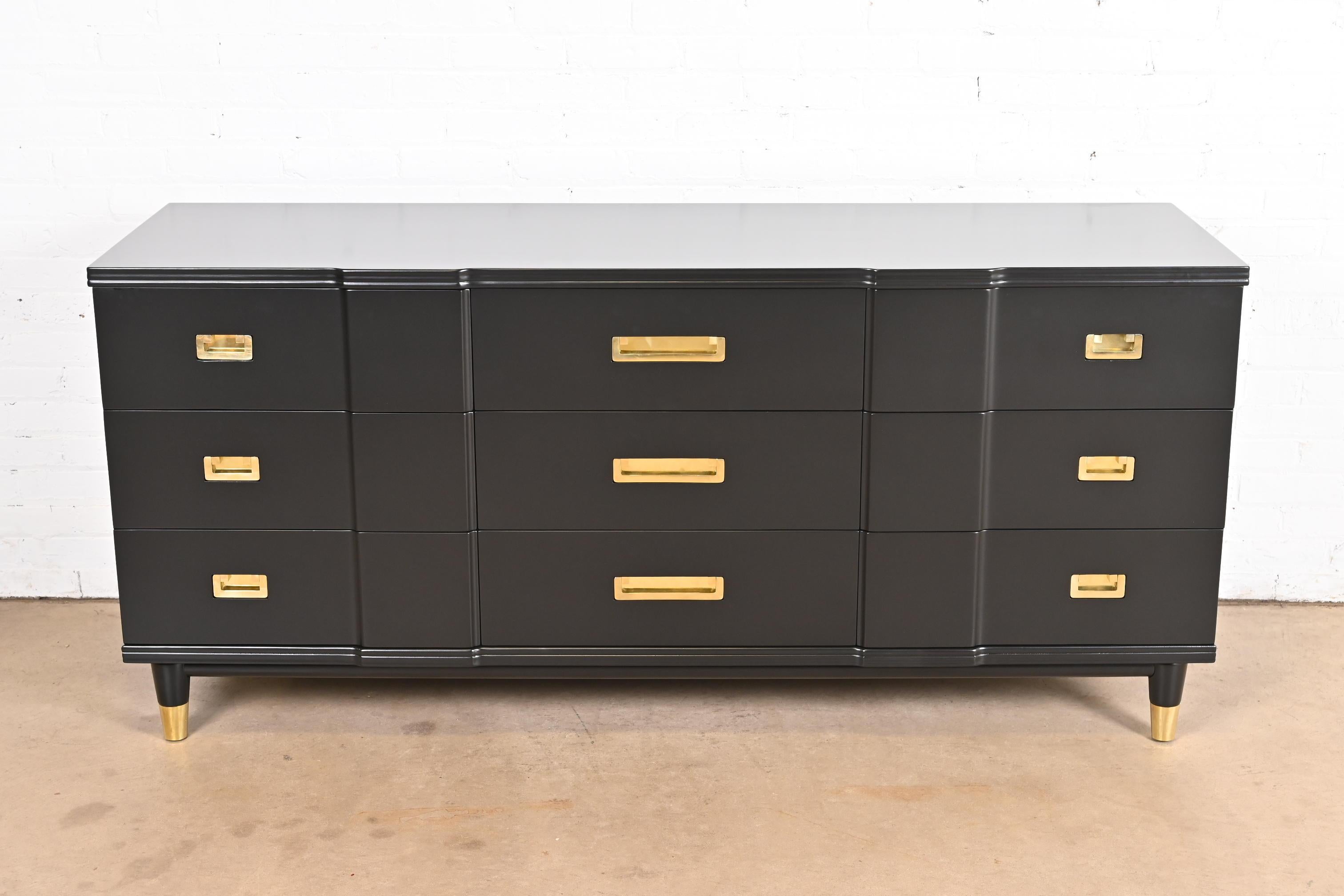 An exceptional mid-century modern Hollywood Regency Campaign nine-drawer dresser

By John Widdicomb.

USA, 1950s.

Black lacquered solid cherry wood, with original brass hardware and brass-capped feet.

Measures: 70.25