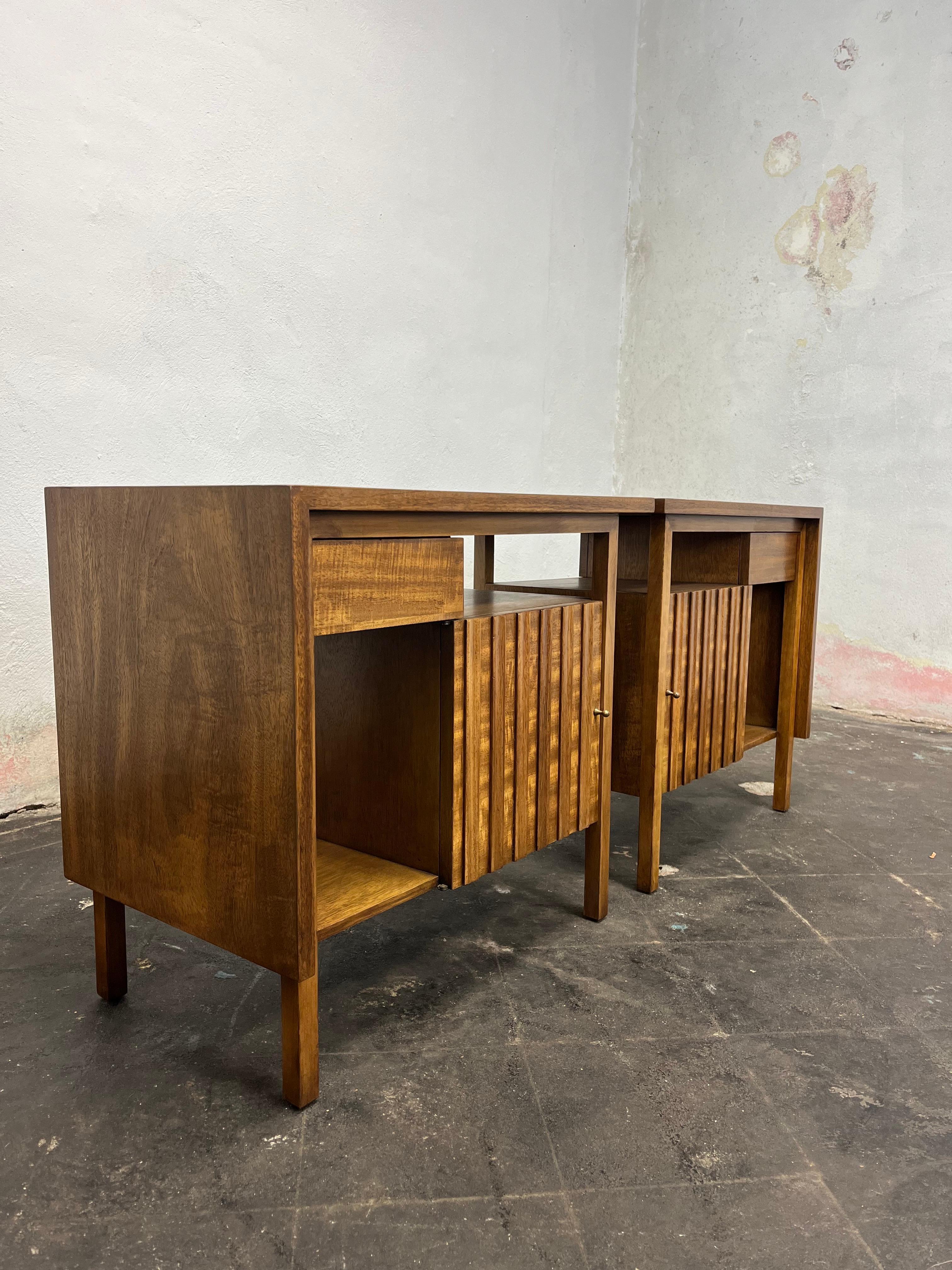 A gorgeous pair of Mid-Century Modern nightstands or end tables. Mid Century John Widdicomb scultped walnut night stands with brass pulls. 
USA, Circa 1950s
The nightstands are finished on the back and could be used floating in a room.
Curbside to