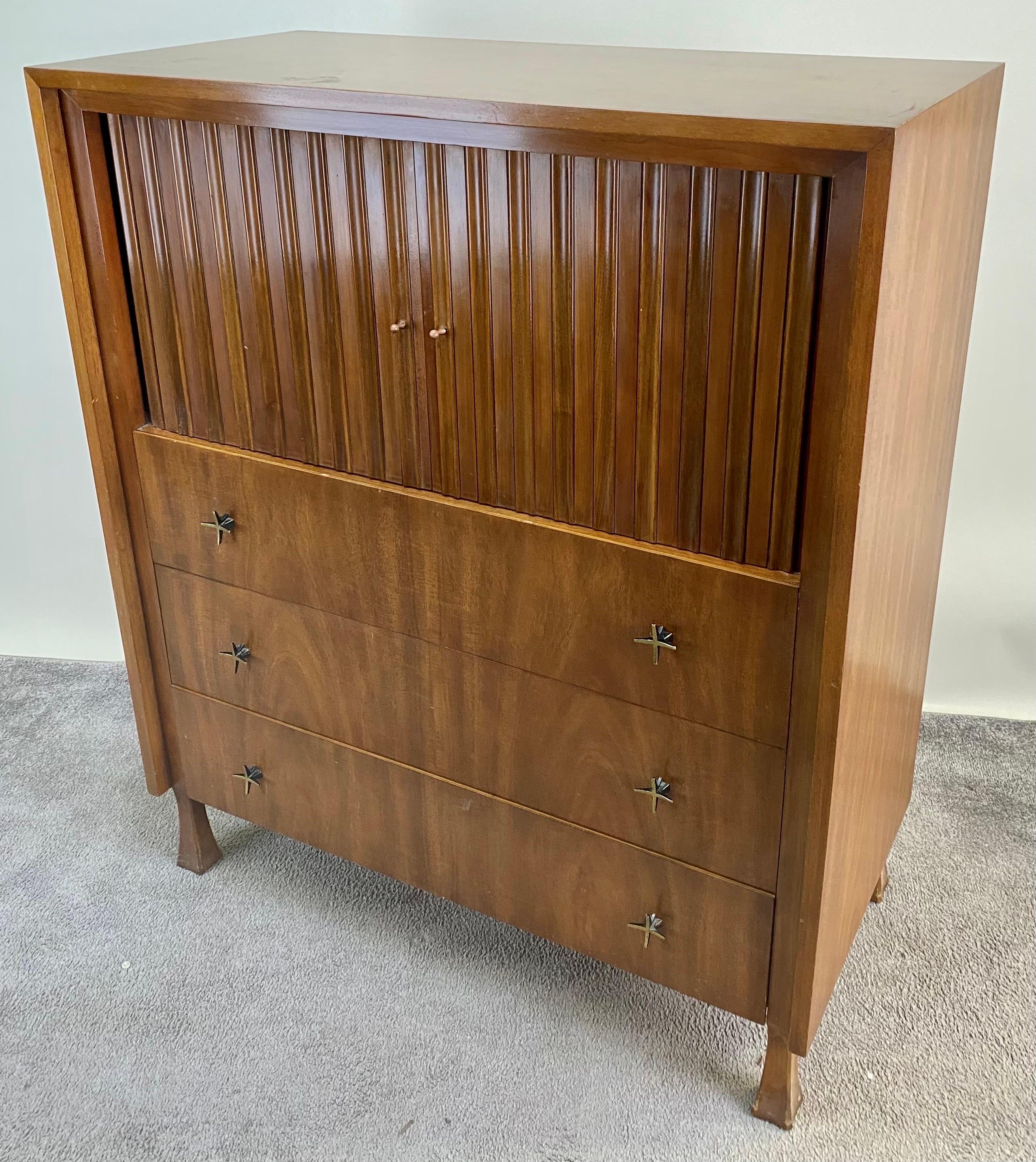 Elevate your living space with the timeless allure of mid-century modern design embodied in this exceptional John Widdicomb tall dresser. Crafted from quality walnut wood, this piece exudes sophistication and enduring style. 
The focal point of this
