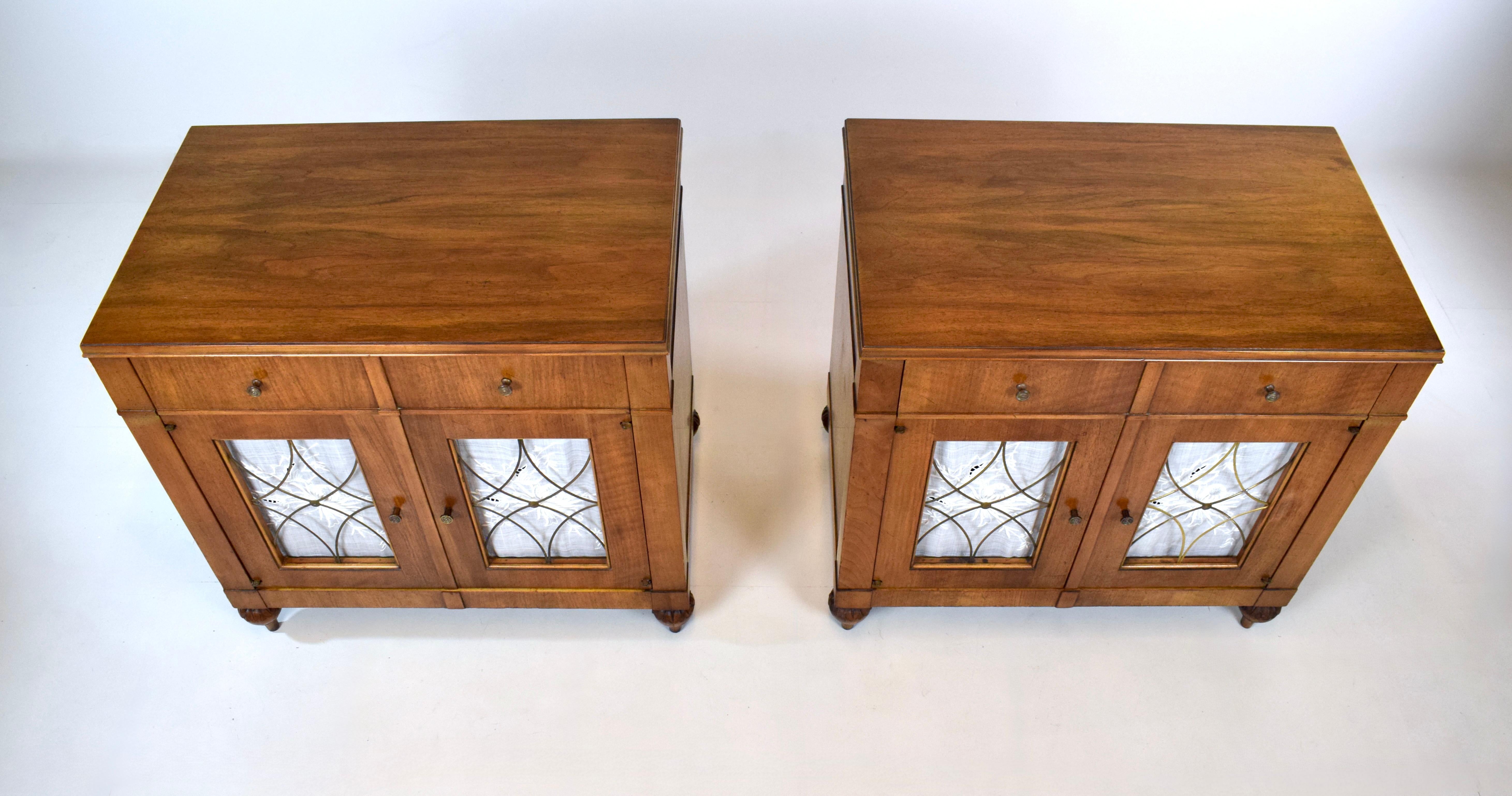 Una coppia di comodini in Wood in stile Reggenza francese della metà del XX secolo con sorprendenti venature del legno infuocato, un cassetto singolo, due ante a traliccio in ottone traforato impreziosite da pannelli di lino floreali ricamati a mano