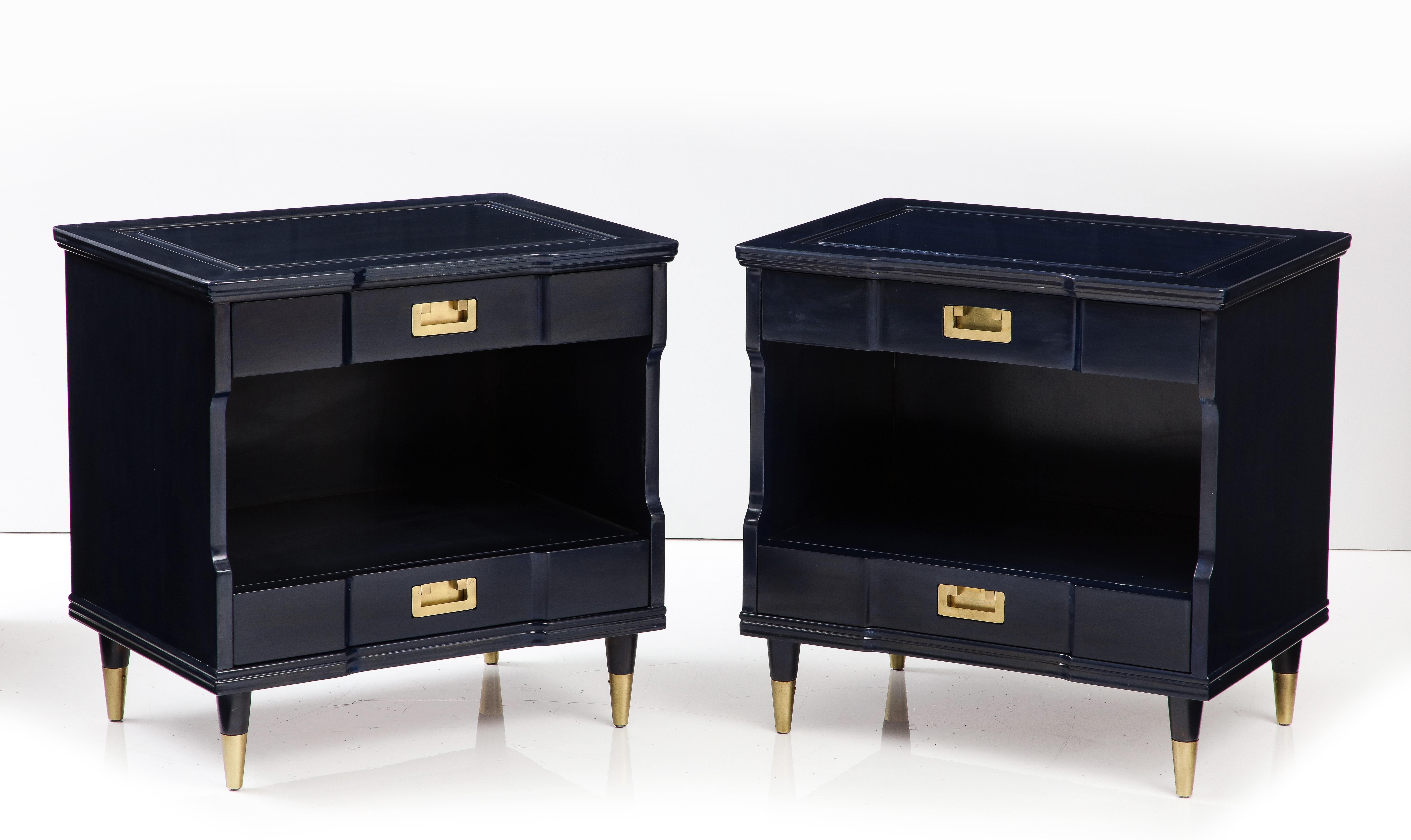 Pair of Mid-Century Modern nightstands featuring a custom stain color in a dark sapphire/midnight blue and brushed solid brass hardware and sabots. Night stands have 2 drawers, upper drawer stamped John Widdicomb Co.