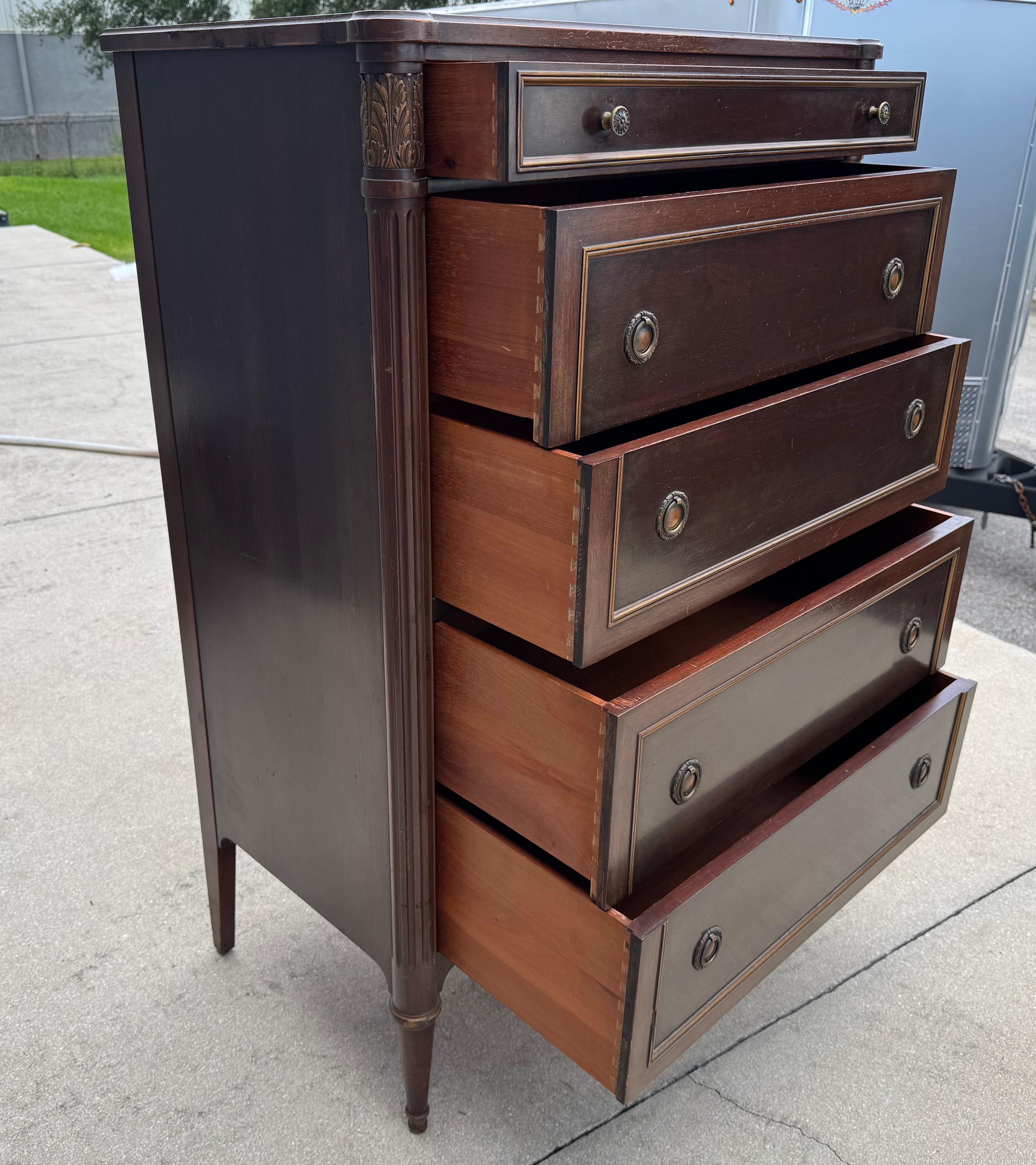 Commode de style néoclassique des années 1950 fabriquée par Widdicomb Co. de Grand Rapids, conçue par Ralph H. Widdicombe. Cinq tiroirs à queue d'aronde s'ouvrent avec des poignées rondes en laiton pressé et sont décorés de façades en bois. Les