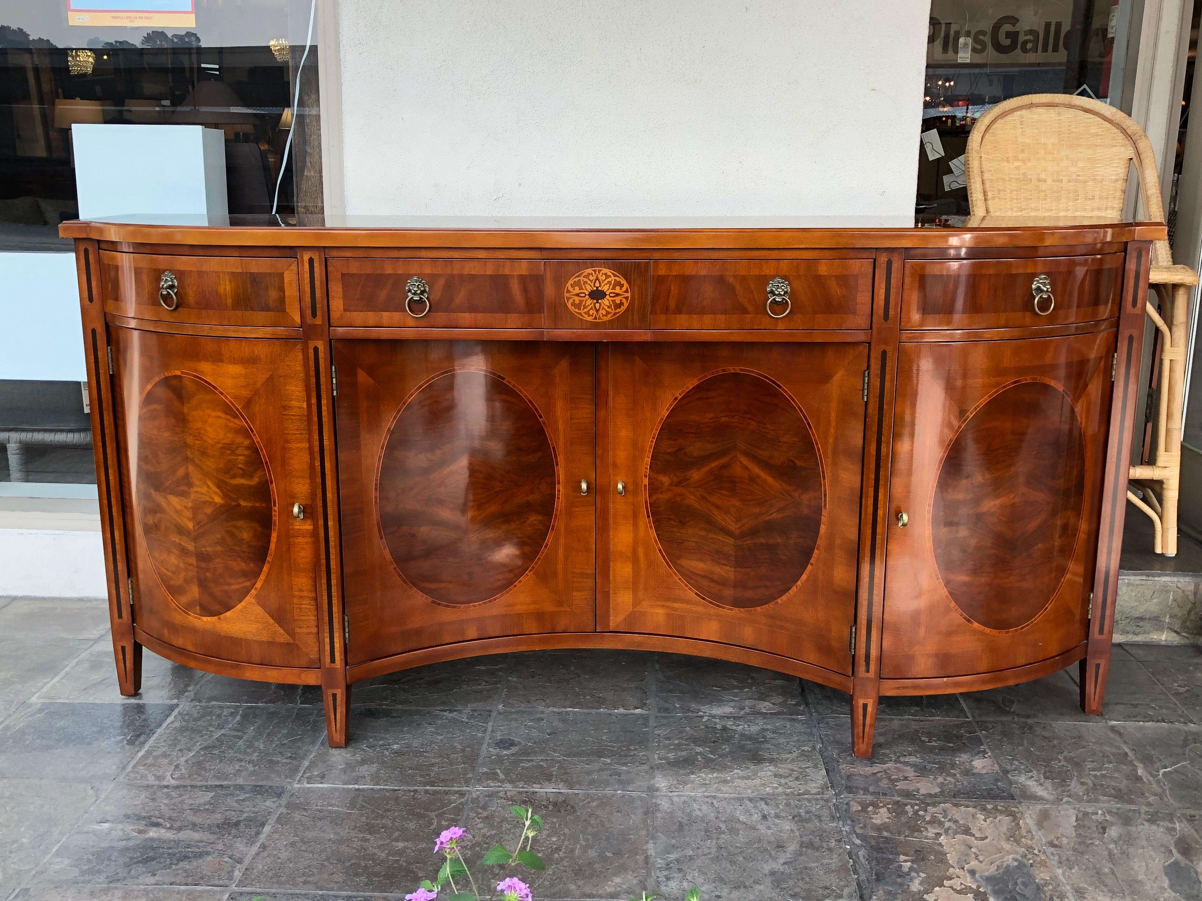 A Russian credenza mahogany inlaid sideboard buffet by John Widdicomb. A fine example of a neoclassical Russian credenza that features lion head drawer pulls and an elaborate inlaid decoration. The center drawer features a custom silverware drawer