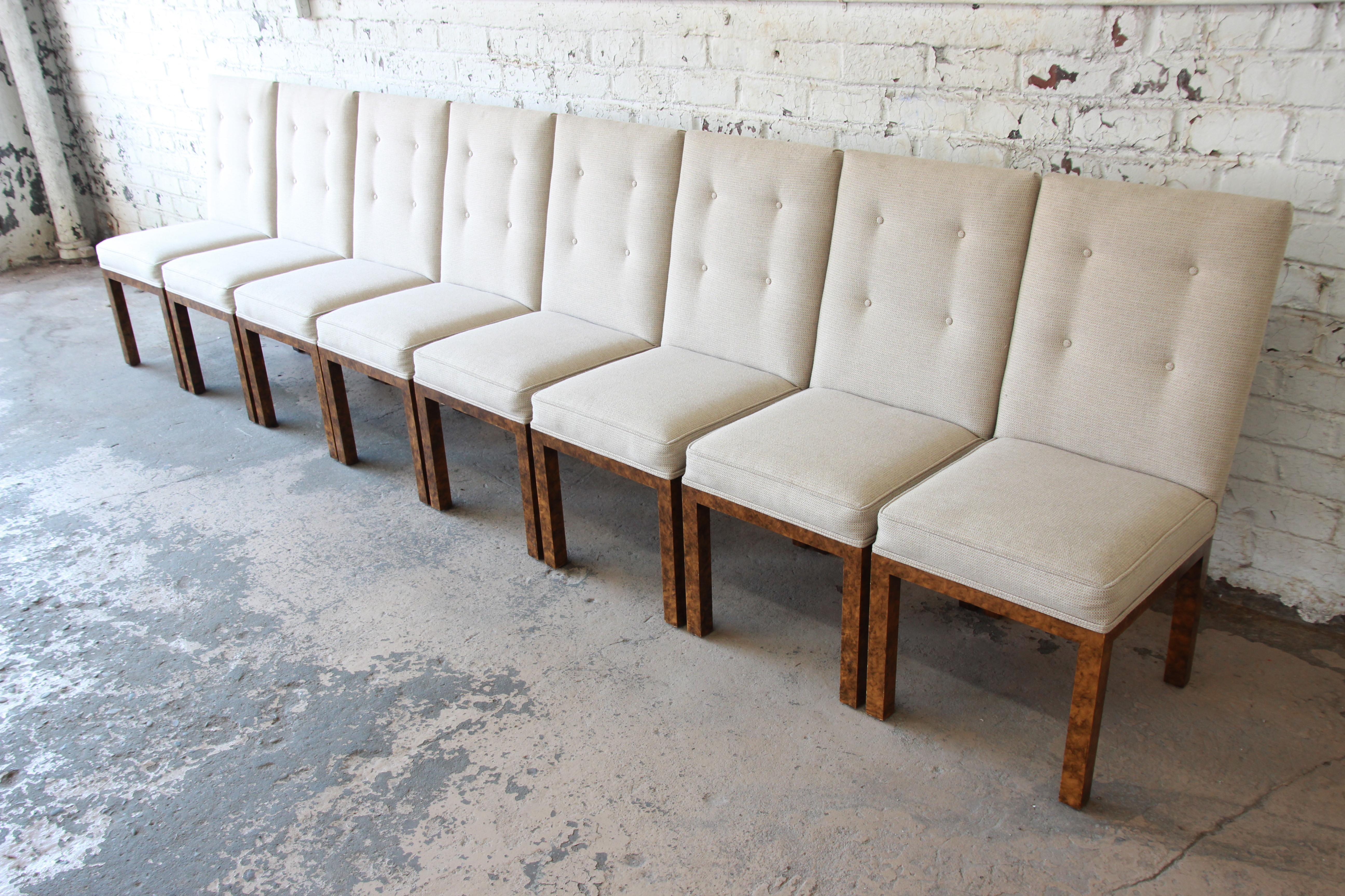 A fantastic set of eight Parsons style dining chairs by John Widdicomb. The chairs feature a simple and elegant design, with unique faux tortoise shell legs and beige upholstery. The original John Widdicomb label is present on the underside of each