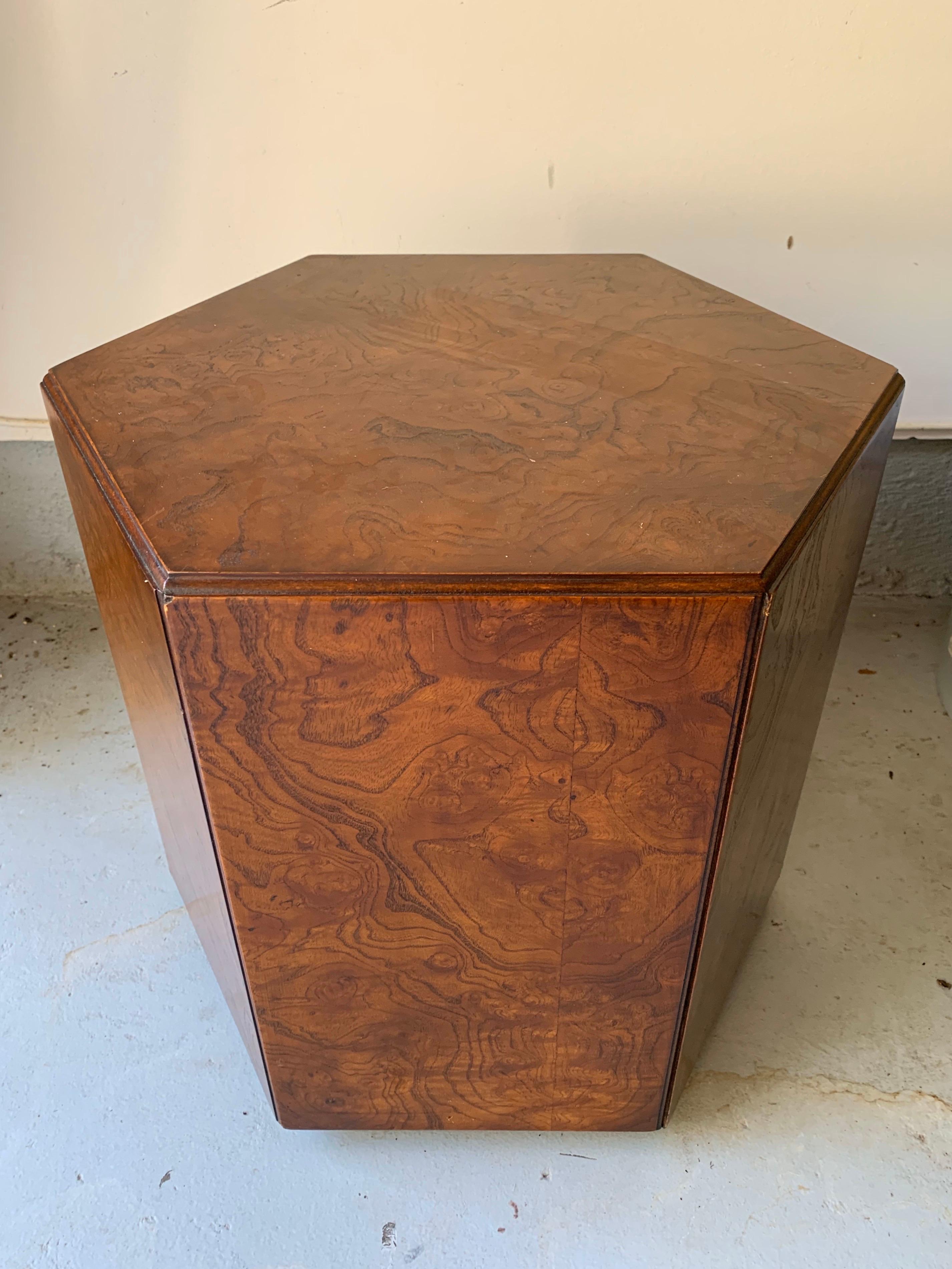 A burl wood occasional or low end table having a Pentagon shape made by John Widdicomb furniture company. USA, circa 1950. 

Features a four caster wheeled base for easy mobility.

Signed in underside with maker's brass metal tag and