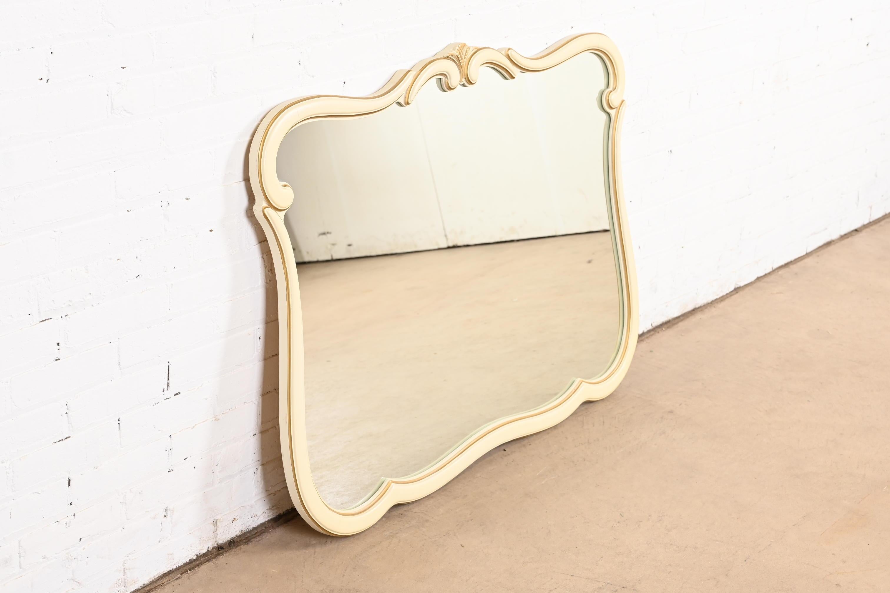 Miroir mural de style provincial français Louis XV, laqué crème et encadré de dorures.

À la manière de John Widdicomb (produit par Carolina Mirror Co.)

USA, Circa 1960

Dimensions : 44,75 