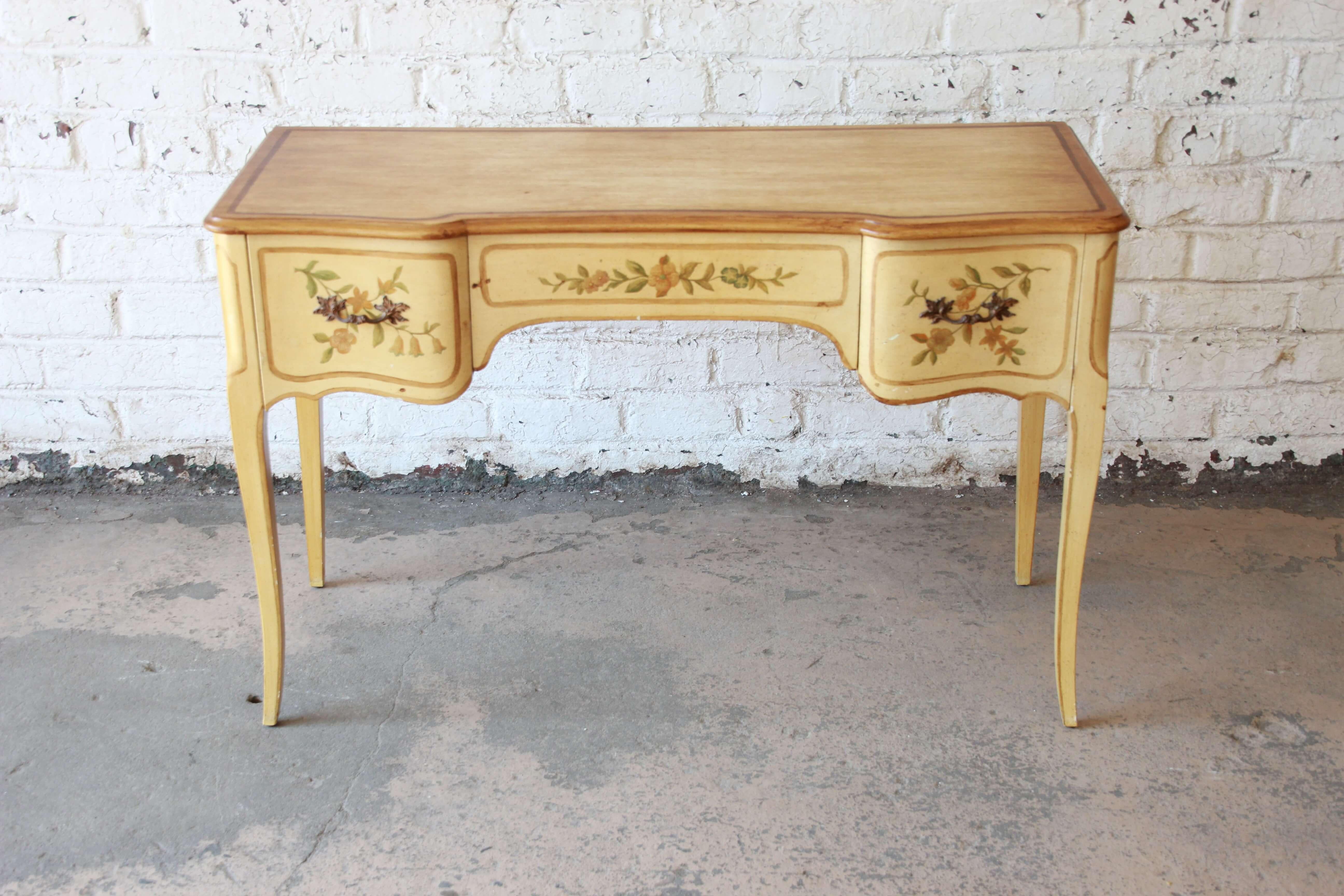 Offering a beautiful painted French writing desk or vanity by John Widdicomb. The desk features classic French design with two large drawers on each end and a long center drawer. Drawer have floral accent paints and all open and close smoothly. The