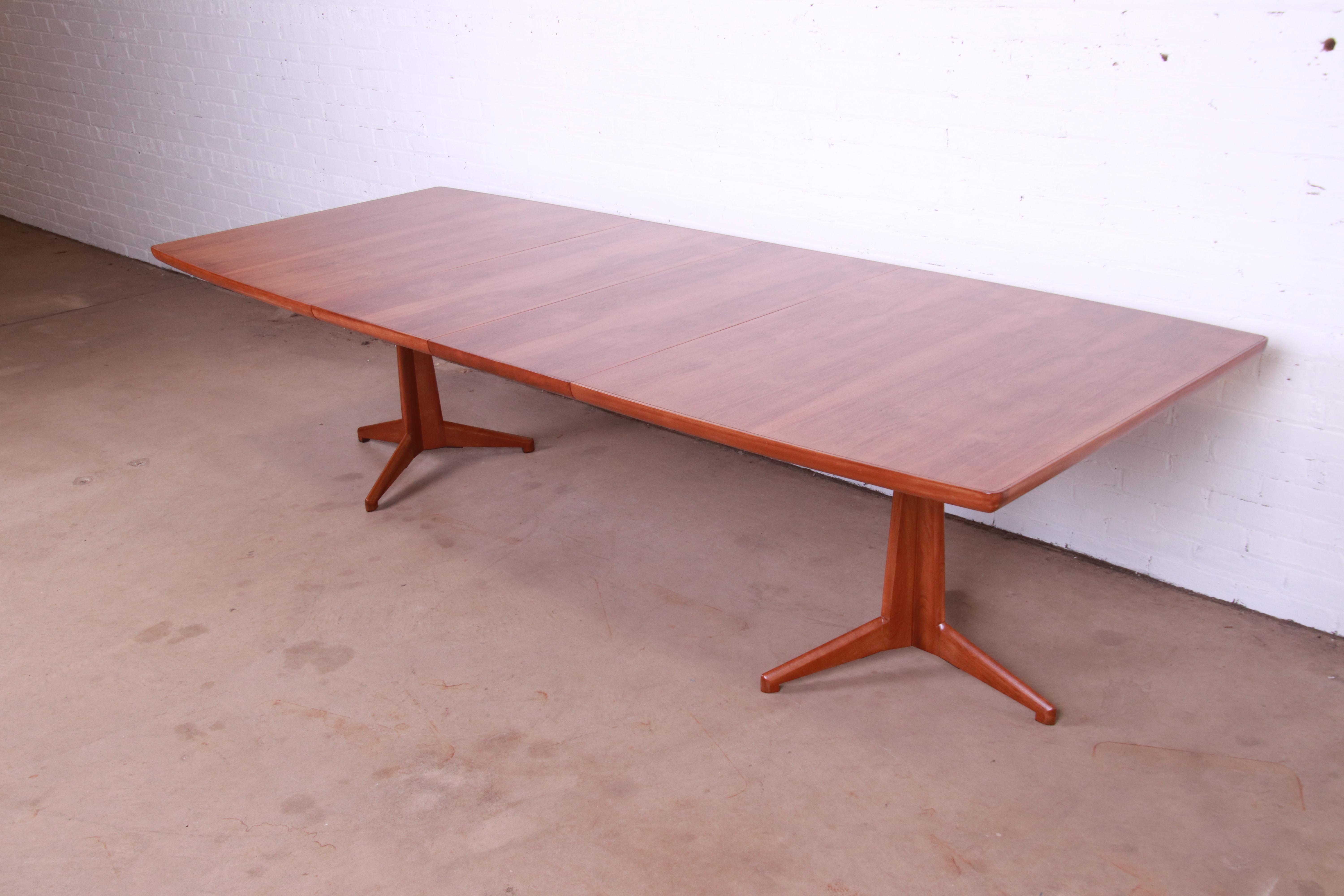An exceptional Mid-Century Modern boat-shaped double pedestal extension dining table

By John Widdicomb

USA, 1950s

Stunning book-matched figured walnut top, with sculpted solid walnut pedestals.

Measures: 71.25