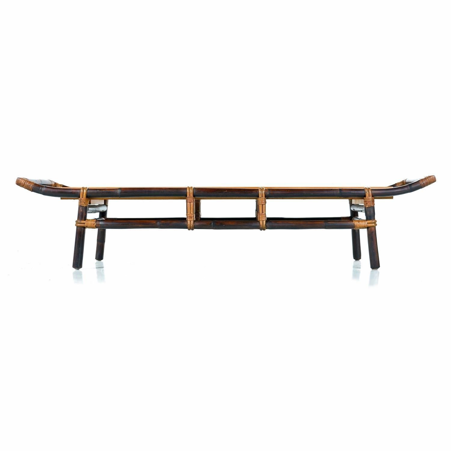 This unique bamboo and rattan pagoda style coffee table was designed by John Wisner for Ficks Reed, circa 1950s. John Wisner graduated from Parsons School Of Design in 1935 and designed for both private clients, and corporate clients including