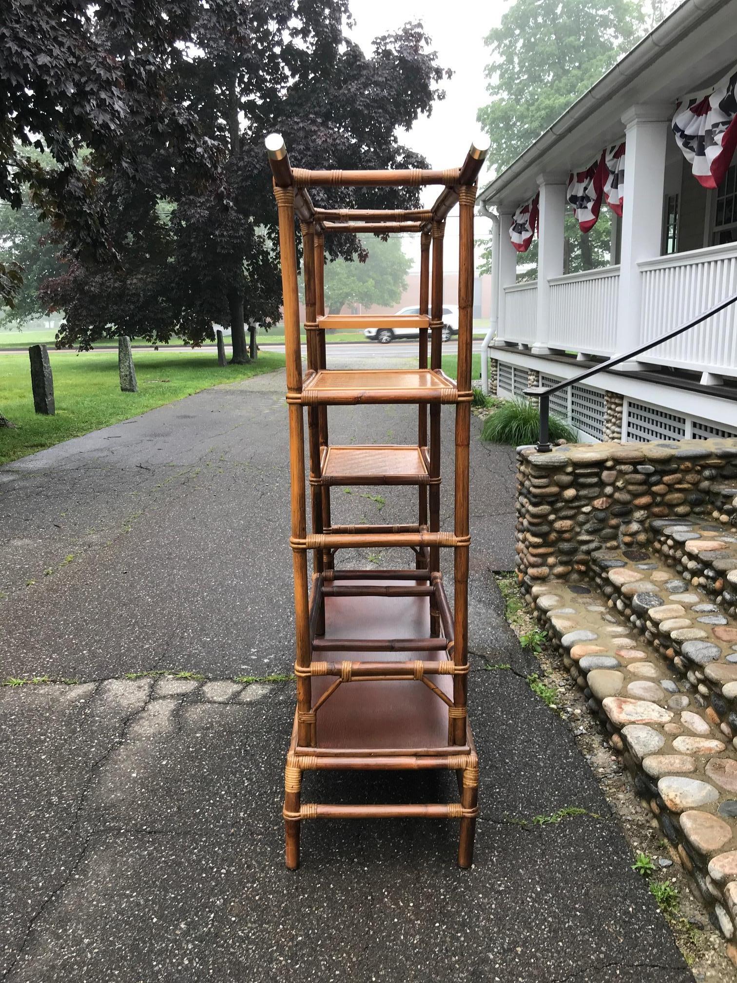 A rare Ficks Reed étagère designed by John Wisner with inset wooden bookshelf. Shelves have woven rattan surfaces and framework is finished with brass caps.