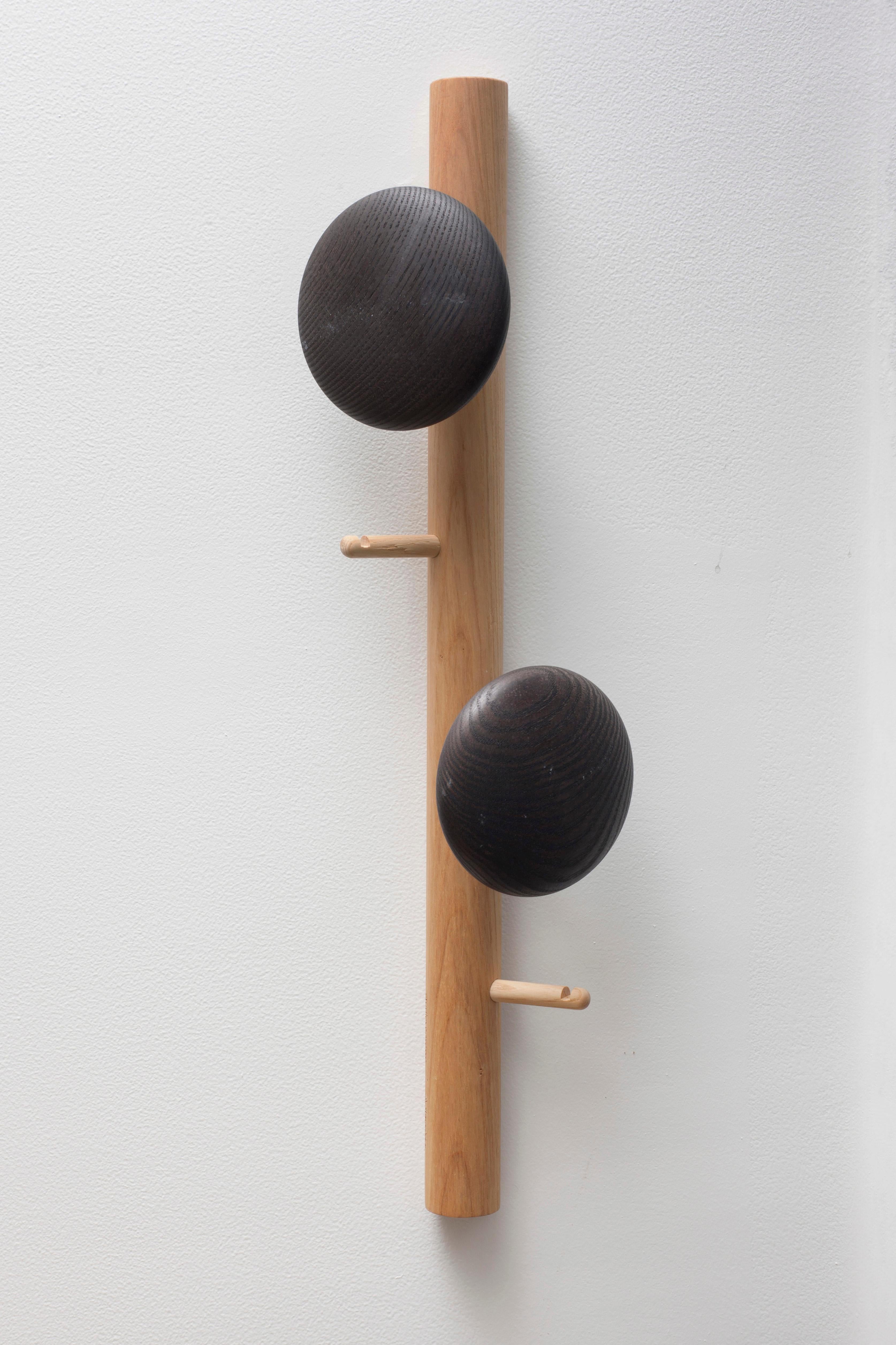 Coat rack in turned solid ash. 
Wall-mounted, it (and the coat hooks) are available in natural or black oiled versions.
Exclusive design by Studio Ventotto for Adentro.