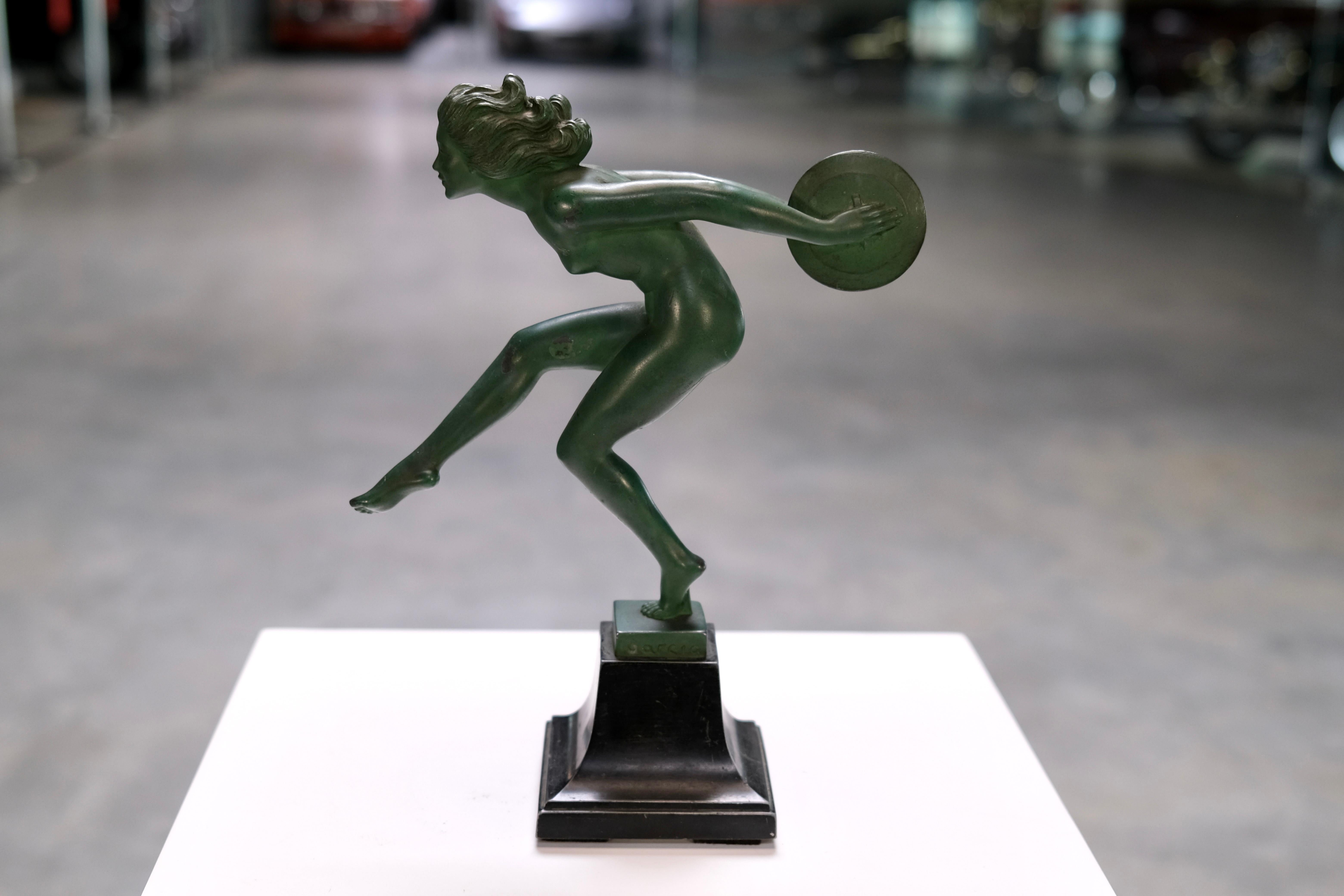 This expressive Art Deco sculpture titled “Joie” (French for “Joy”) beautifully captures the spirit of movement and vitality characteristic of the Art Deco era. The nude female dancer, mid-leap, balances a discus with dynamic grace and exudes
