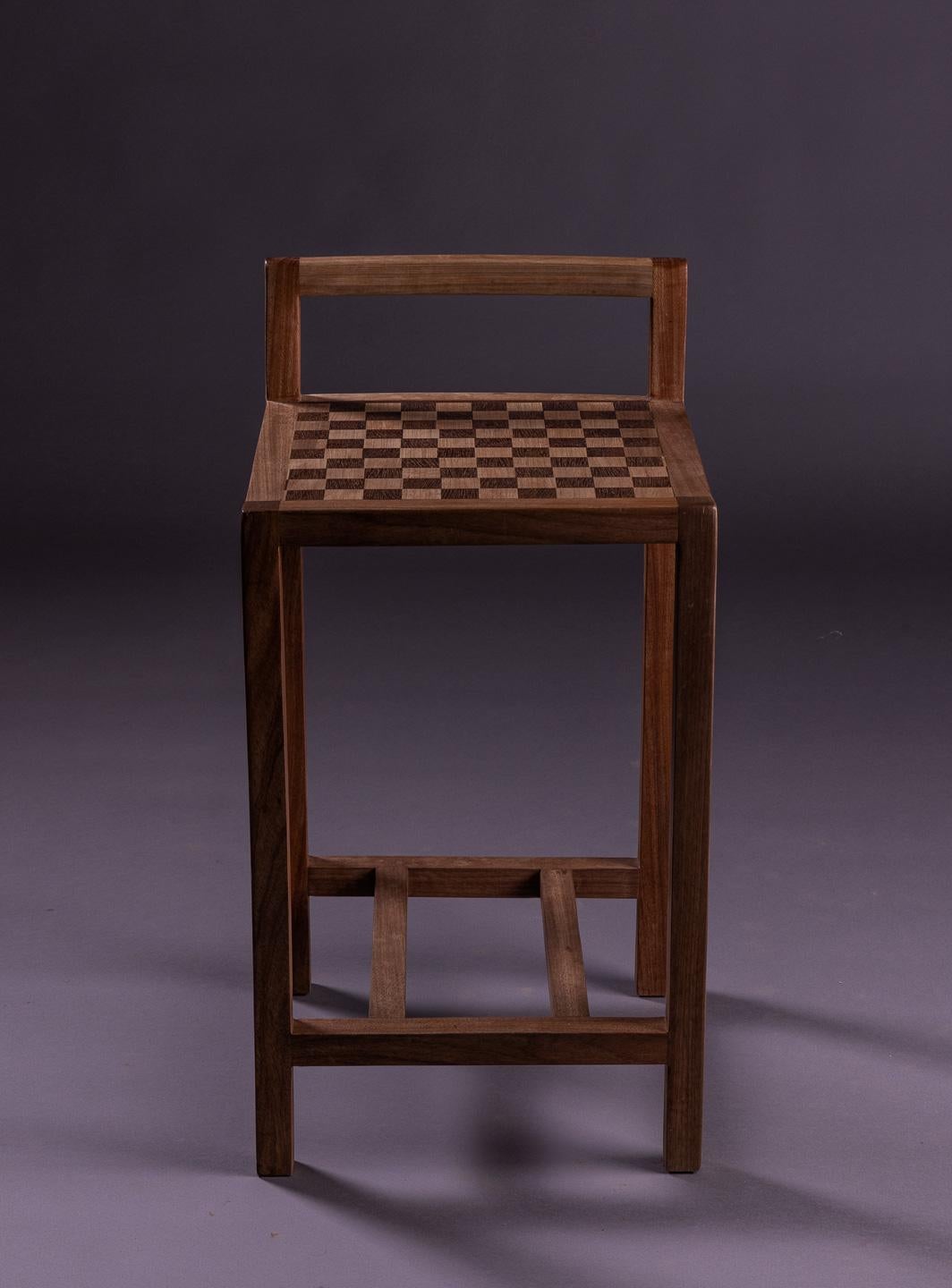 Le charmant tabouret Jojo est doté d'une assise en marqueterie à carreaux, habilement travaillée avec les bois nobles Jequitibá et Sucupira. Sa structure robuste est également fabriquée en Jequitibá de haute qualité, ce qui lui confère durabilité et