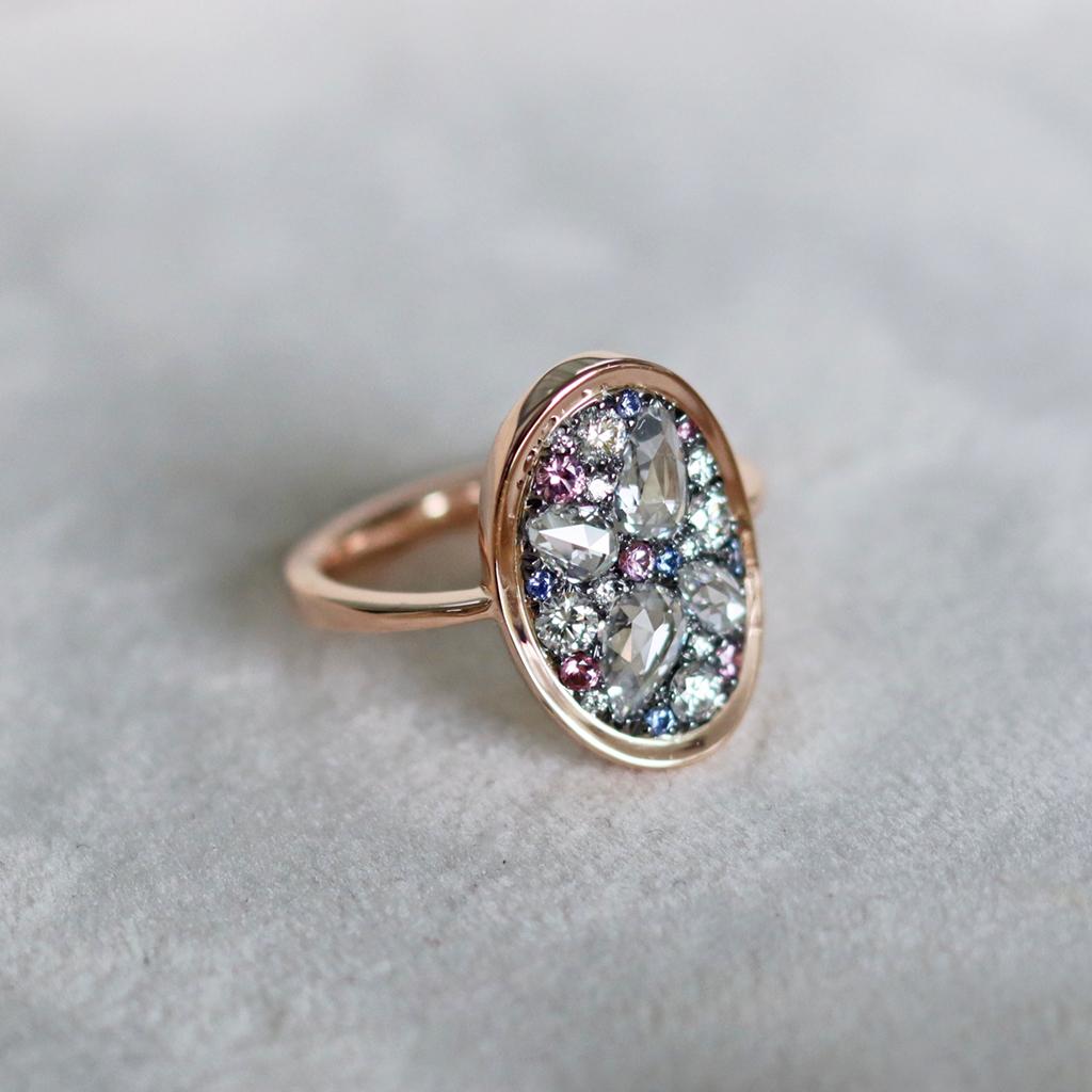 This White Diamond Ring with very small Pink and Blue accents, is a One of a kind ‘Starstruck’ ring handmade in Belgium by Jewelry designer Joke Quick in 18K Rose gold 4.5 g & blackened sterling silver 1 gram (The stones are set on silver to create