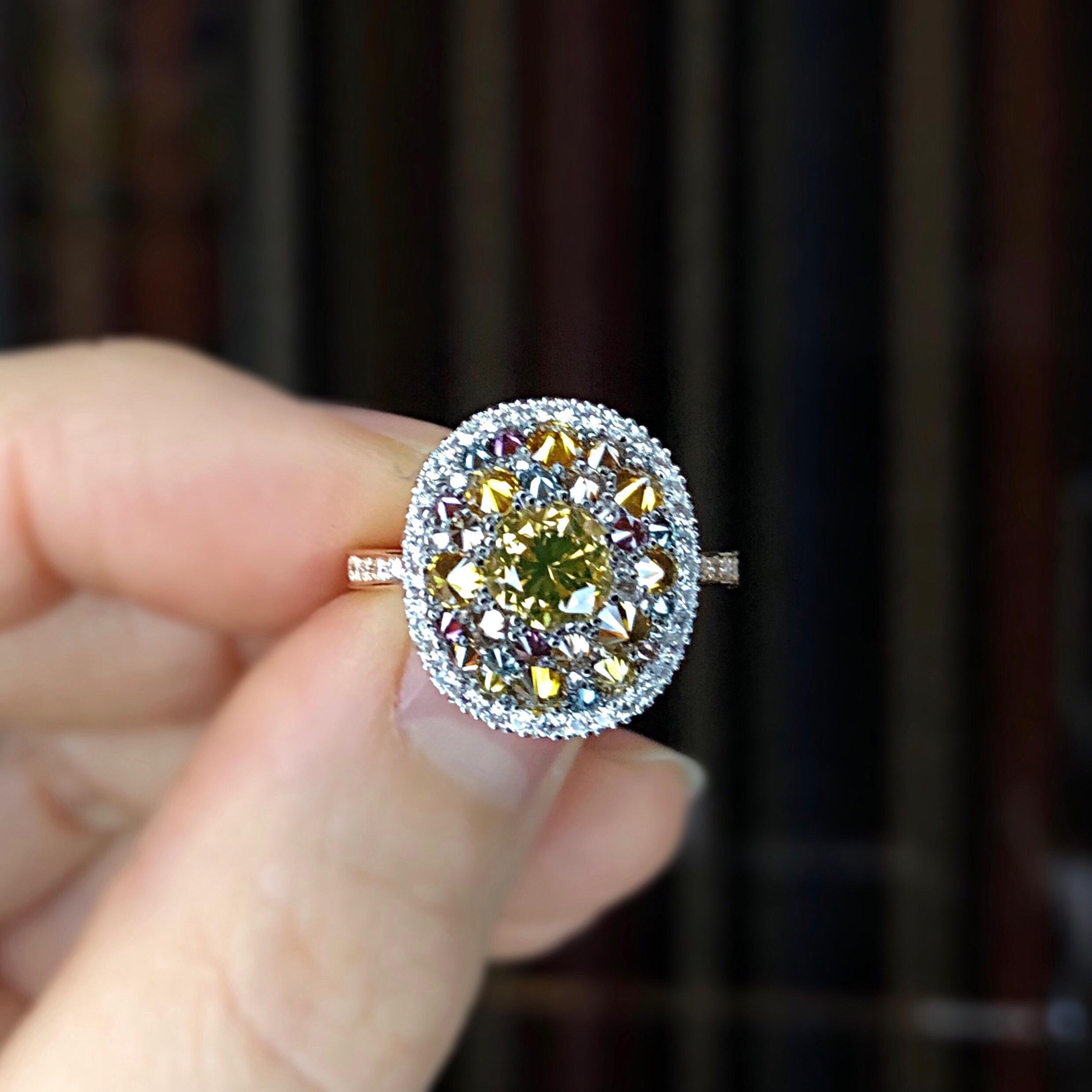One of a kind ring in 18K Rose & White gold 7,9 g set with a fancy Cognac diamond centerstone 1,05 carat., white DEGVVS diamonds, Fancy yellow , natural coloured Blue & purple diamonds 1,36 ct. Total diamonds: 2,41 carat.
Size EU 52,5 US 6,25 . This