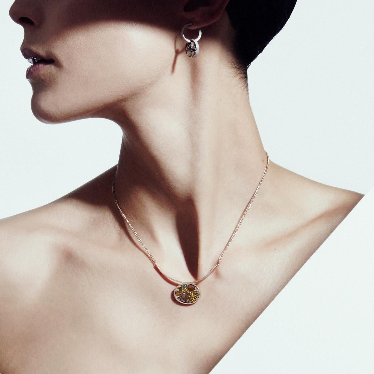 Pendant with neclace, handmade in Belgium in 18kt red gold 7,6 g and blackened sterling silver ( the stonesetting is made in blackened sterlingsilver to create a black background for the stones)  Natural coloured blue, brown; yellow & cognac