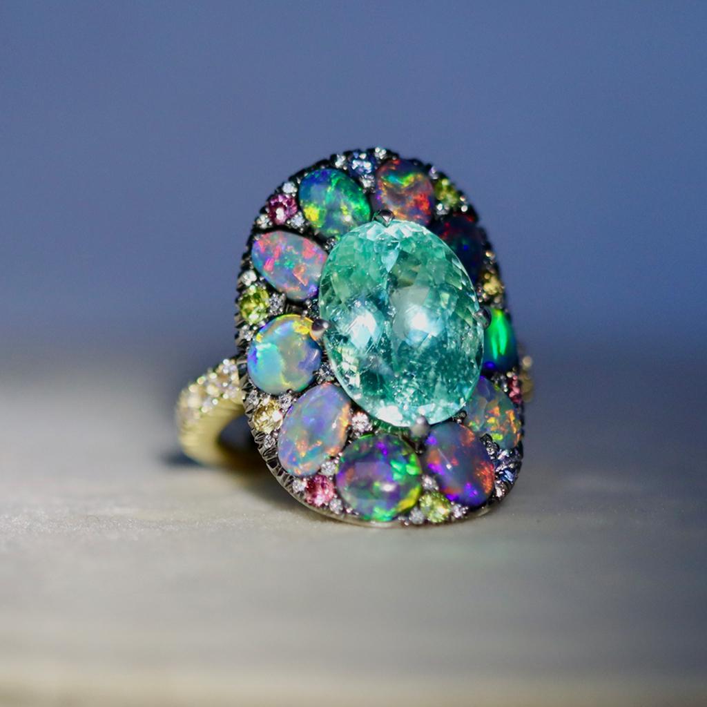 One of a kind ring handmade in Belgium by jewelry artist Joke Quick, in solid 18K Yellow & White gold and handmade the traditional way ( no casting or printing involved ). Set with a 5,67 Carat Neon Green Blue Paraiba Tourmaline, Black Opal
