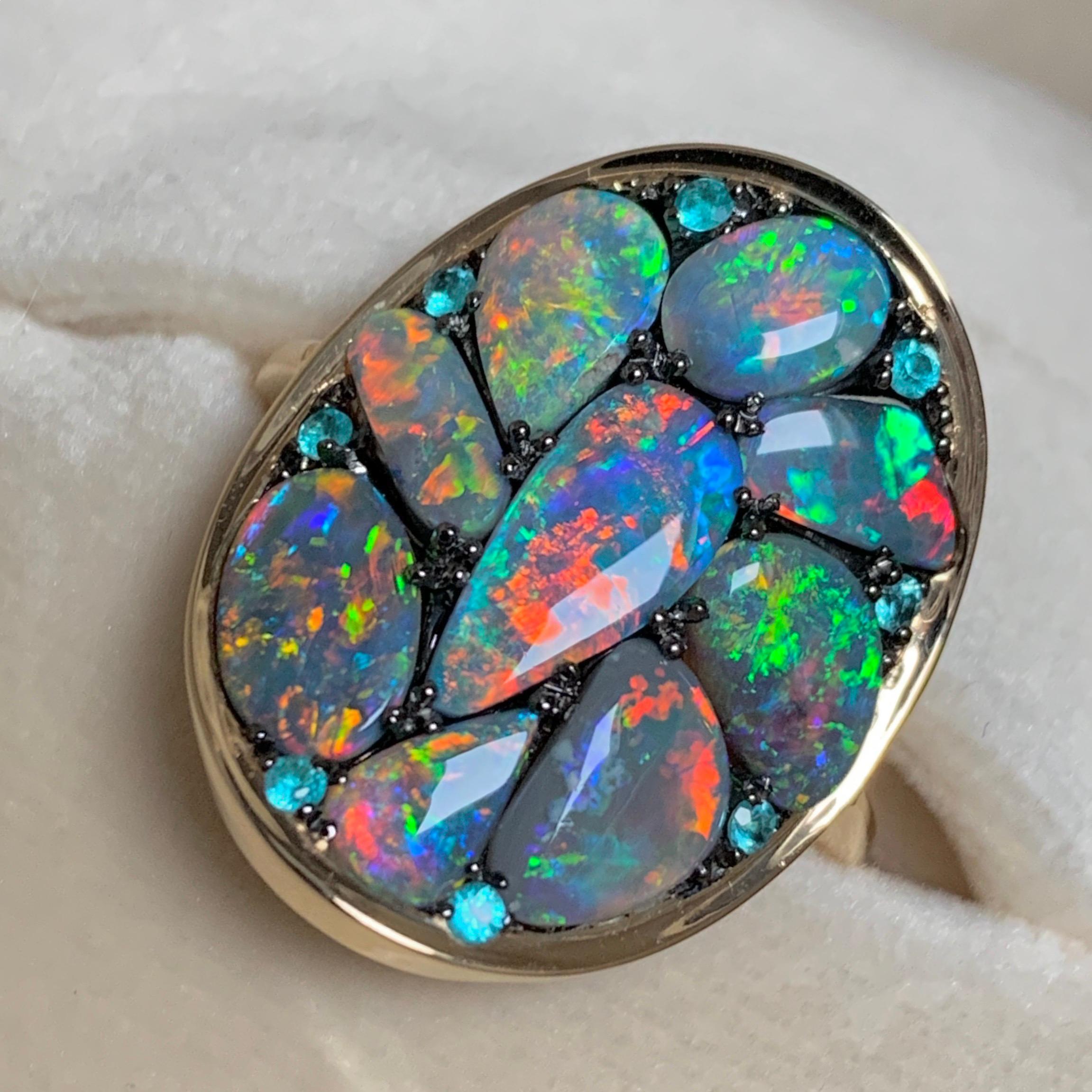 One of a kind ring in 18K yellow gold 6,7 g & blackened sterling silver (The stones are set on silver to create a black background for the stones, the rest of the ring is in 18K gold)
Black Opal cabochons from Lightning Ridge 4,42 carats, Paraïba