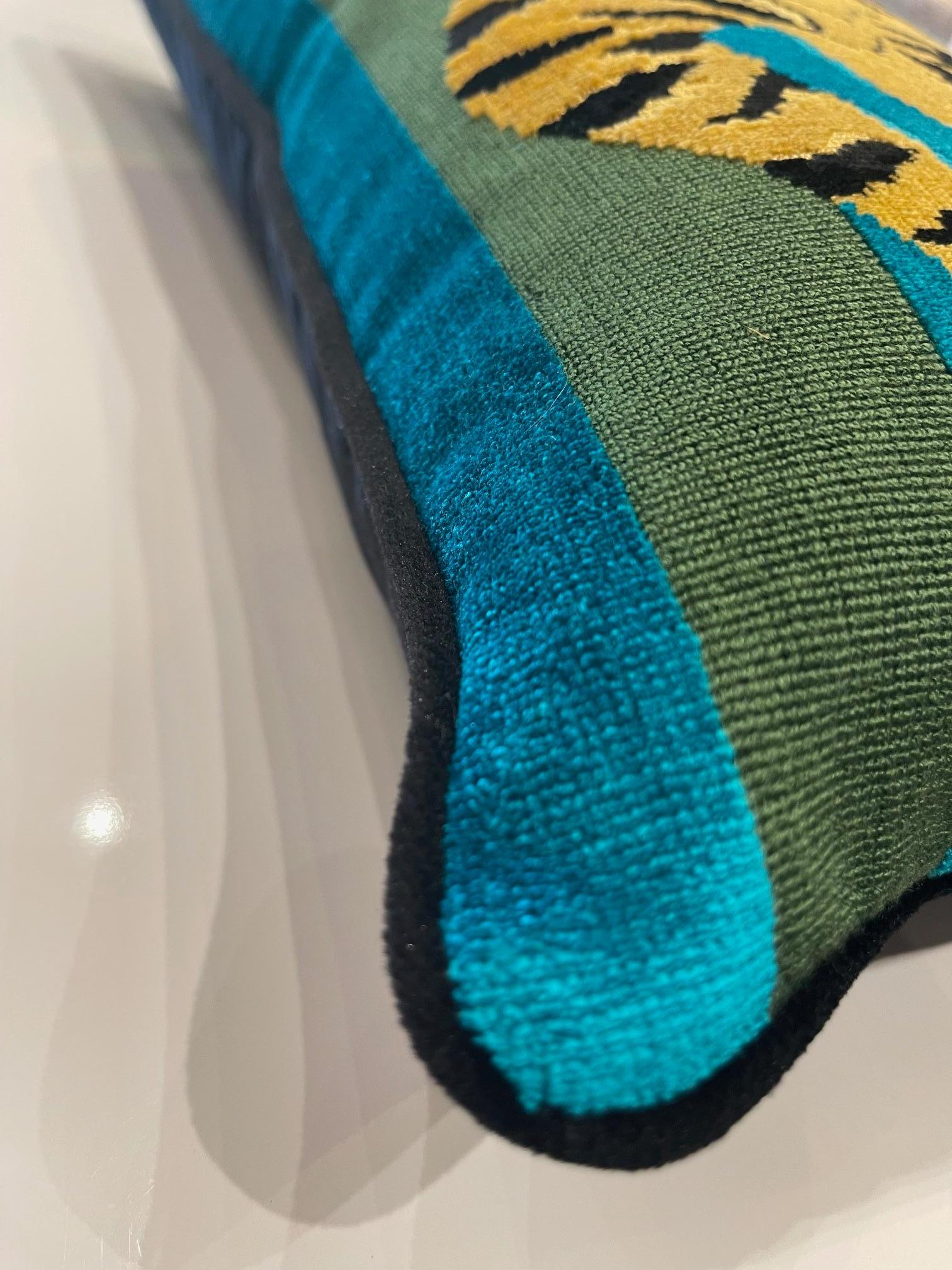 Este atrevido y lujoso cojín tiene el terciopelo Jokhang Tiger de Schumacher, diseñado por Johnson Hartig, que muestra el icónico motivo del tigre tibetano en vivos tonos verdes y azules. Enmarcado con un elegante ribete negro, cada cojín está
