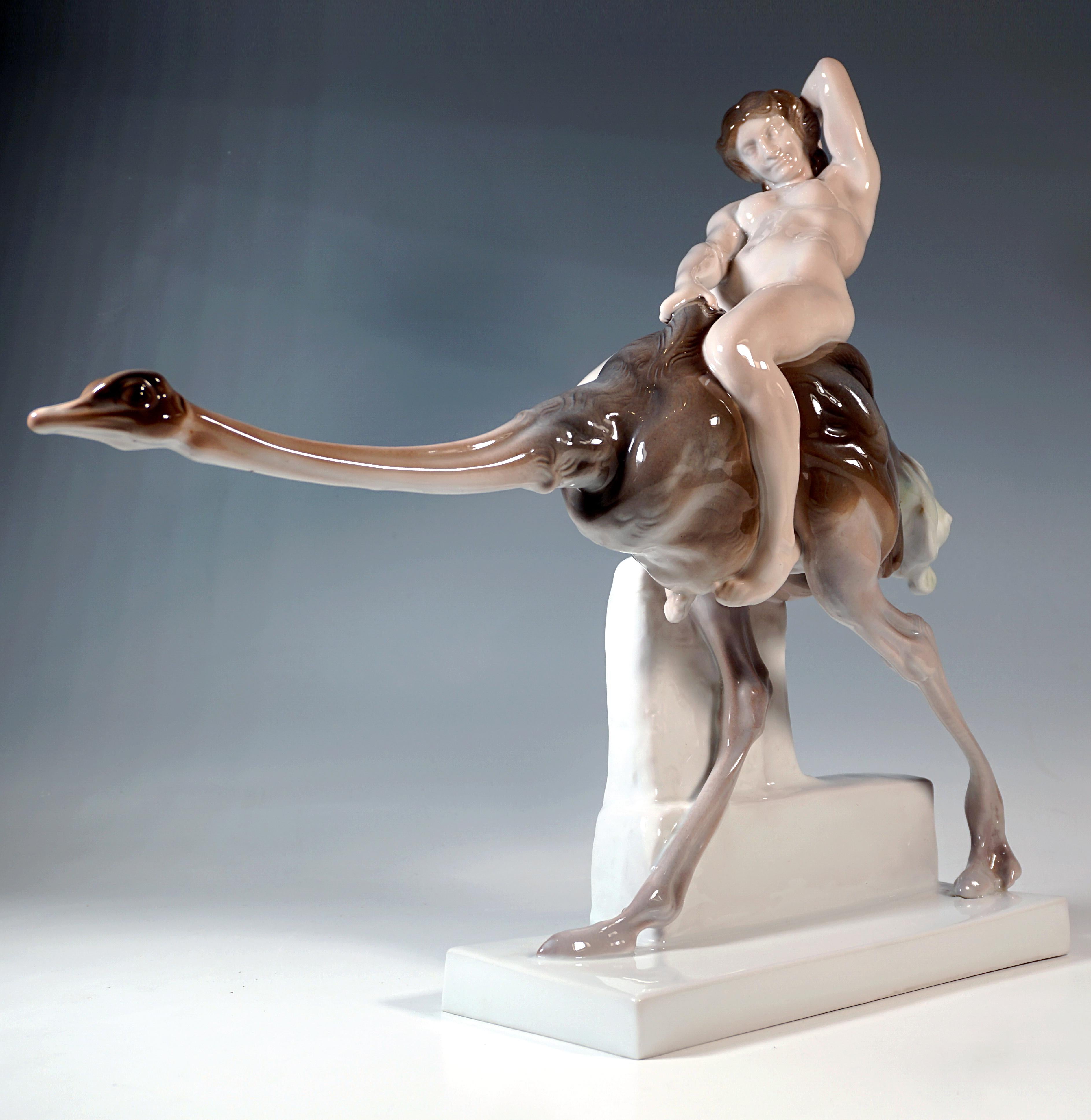 Admirable groupe de figurines Art Nouveau de Rosenthal :
Jeune femme nue aux cheveux savamment attachés assise à califourchon sur une autruche étirant son cou vers l'avant en courant et agrippant de la main droite le plumage dorsal de l'animal, le