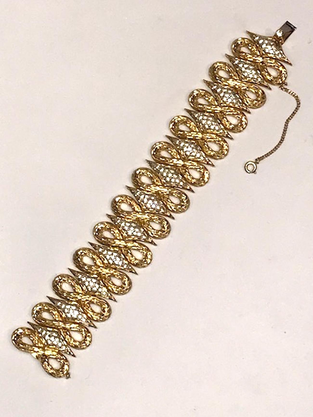A beautiful abstract link design of textured gold figure eight links alternating with elongated and rhinestone set diamond shape links. The rhinestones are set into a rhodium plate finish and framed by the matching textured gold plate of the figure