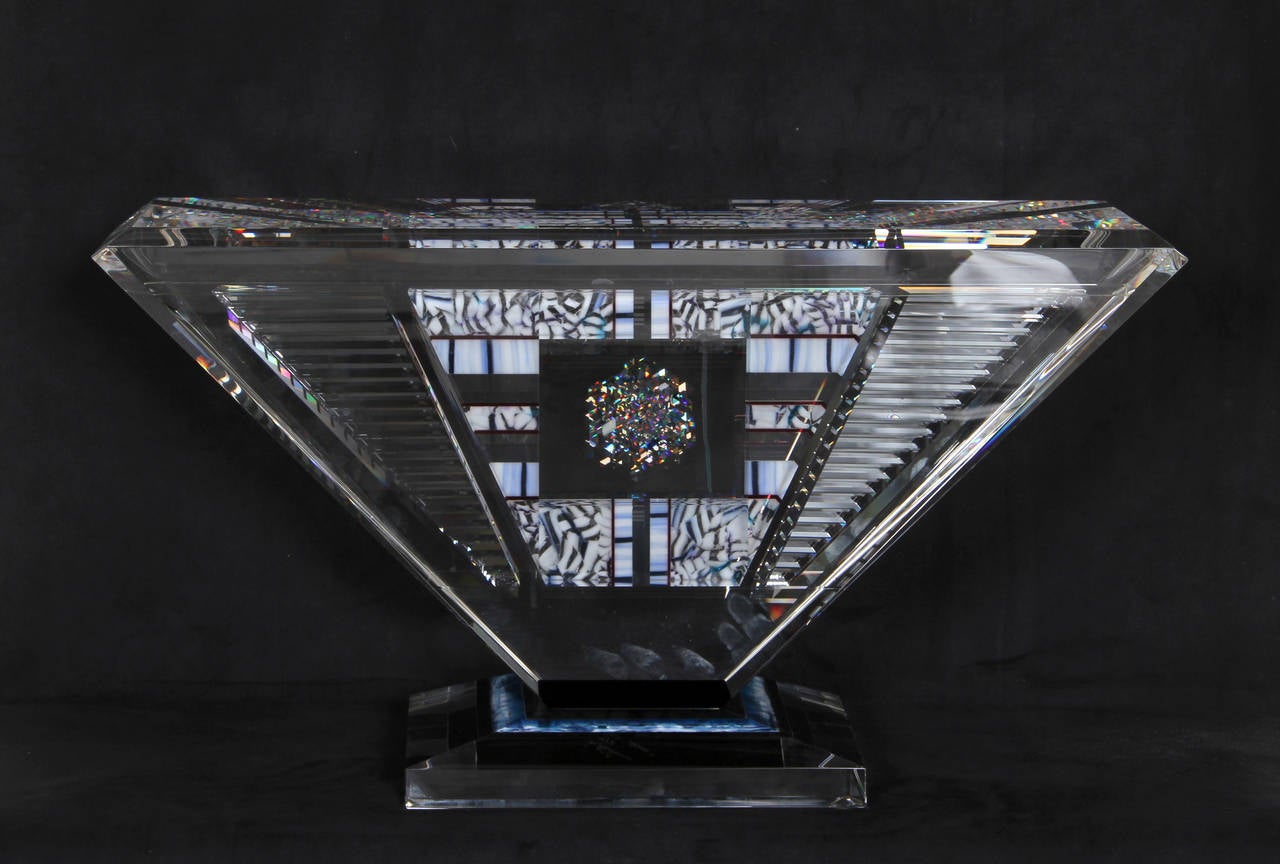 Eine geschliffene Glasskulptur von Joh Kuhn aus dem Jahr 1992. Eine spektakuläre Skulptur aus kristallklarem Glas, die ein kompliziertes Prisma bildet, in dem das Licht in einer Vielzahl optischer Spiele reflektiert wird. 
 
Künstler: Jon Kuhn,