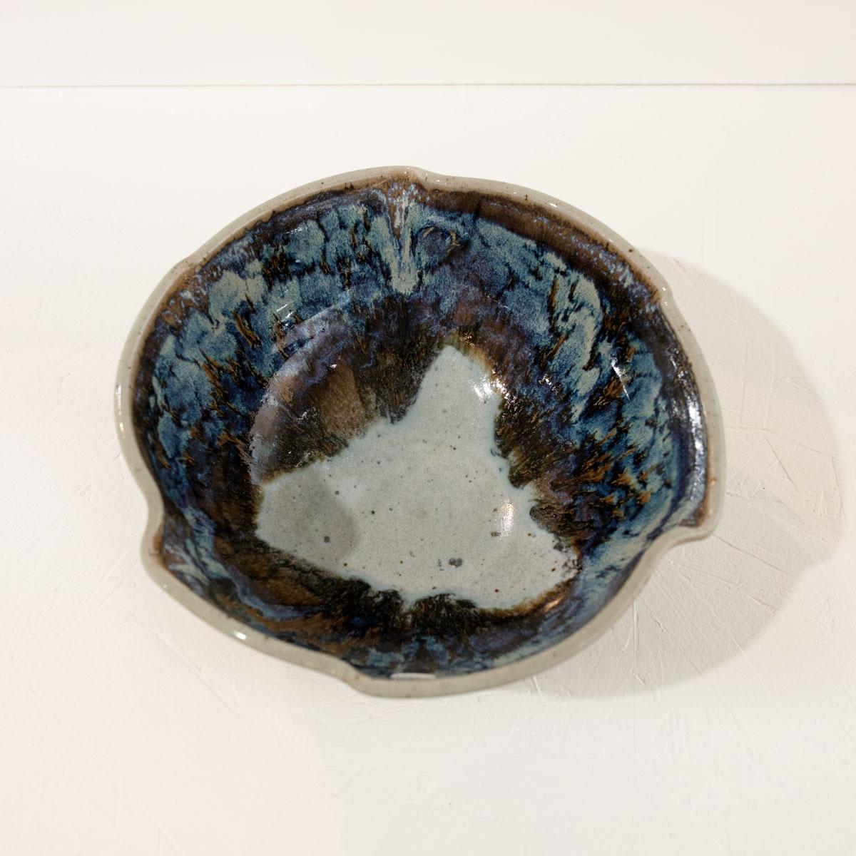 This glazed ceramic bowl features a blue, white, and light umber palette with a creme-toned interior, crimped rim. The artist's stamp is located at the base of the bowl.

Crystalline glazes are special ceramic glazes in which zinc-silicate crystals