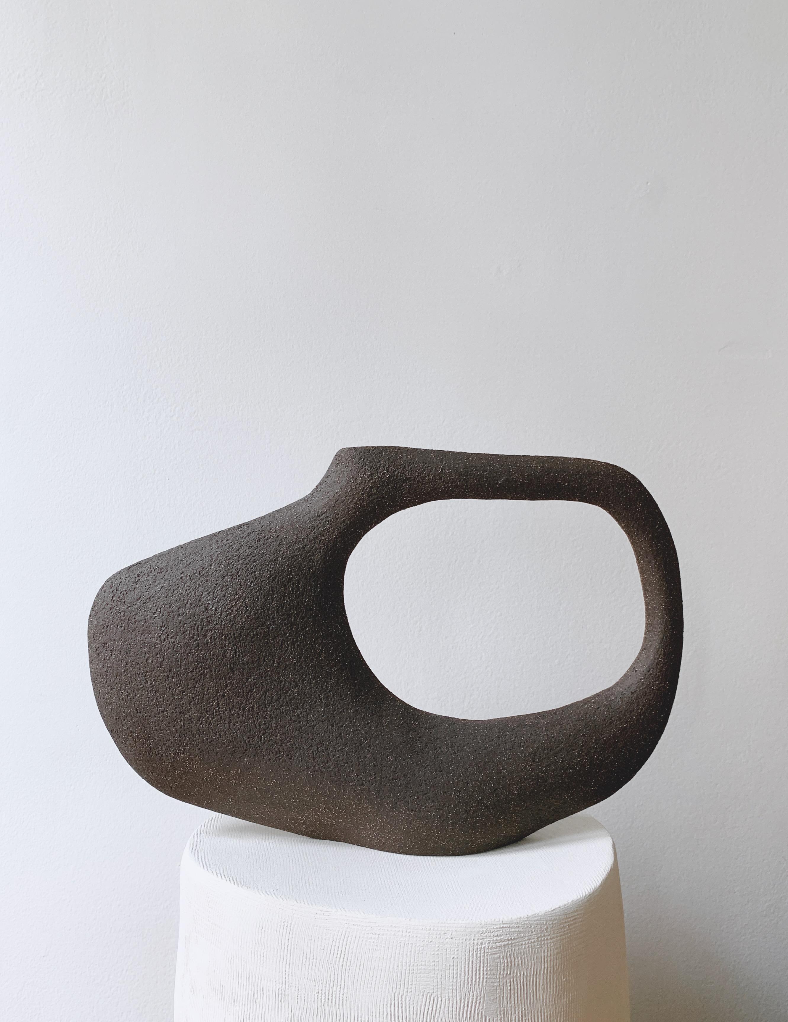 Jon Tribu 5.23 sculpture by Léontine Furcy
Unique piece.
Materials: Raw black sandstone.
Dimensions: L 34 x H 23 cm.

Léontine Furcy, ceramic artist, tells about herself in shapes, textures, curves, asymmetries, purifications. Each of the