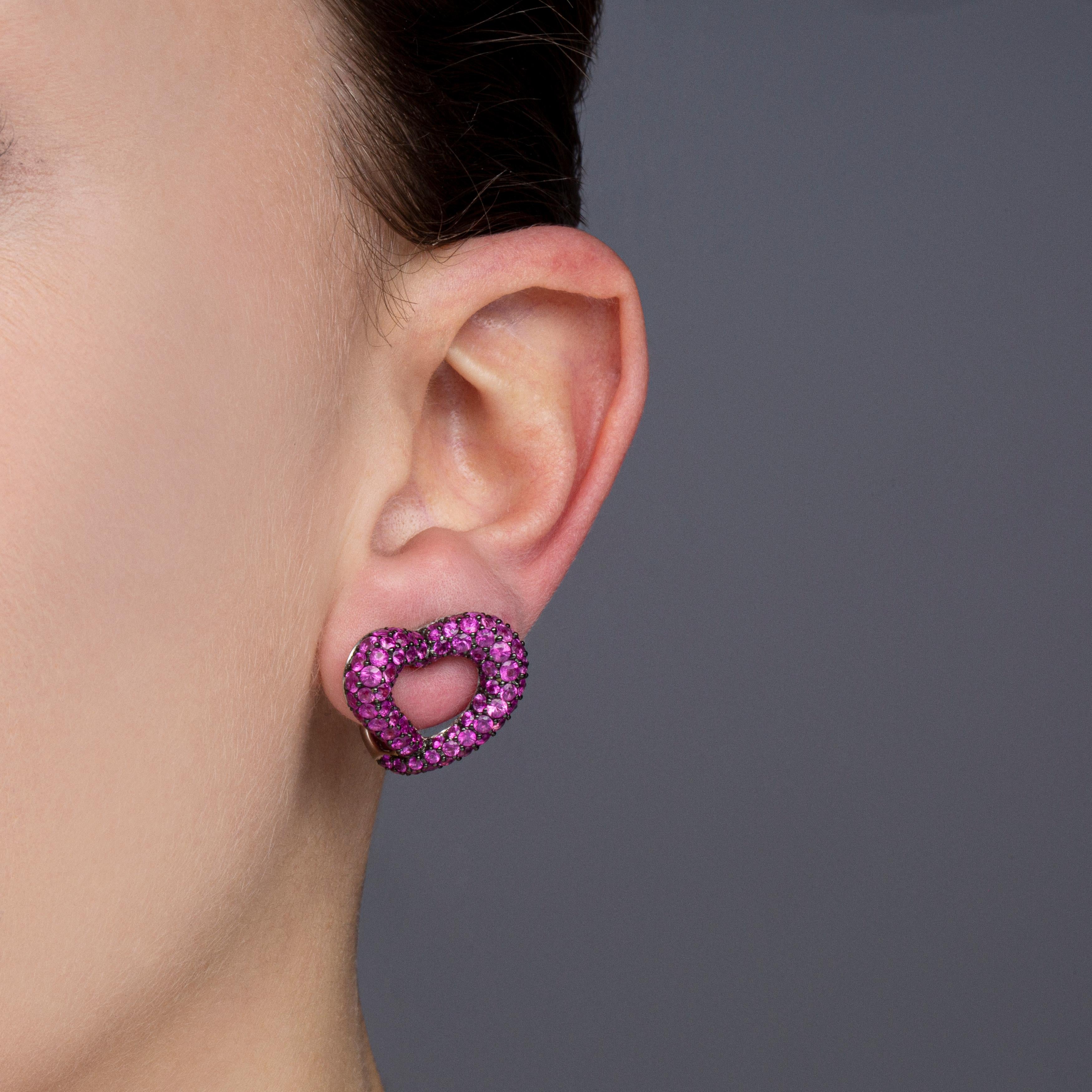 Alex Jona design collection, hand crafted in Italy, open heart ear clips in 18 karat white gold set with 198 intense Pink Sapphires for a total weighing of 8,74 carats with black rhodium setting.
Dimensions : H 0.78 in x W 0.86 in x D x 0.23 in - H