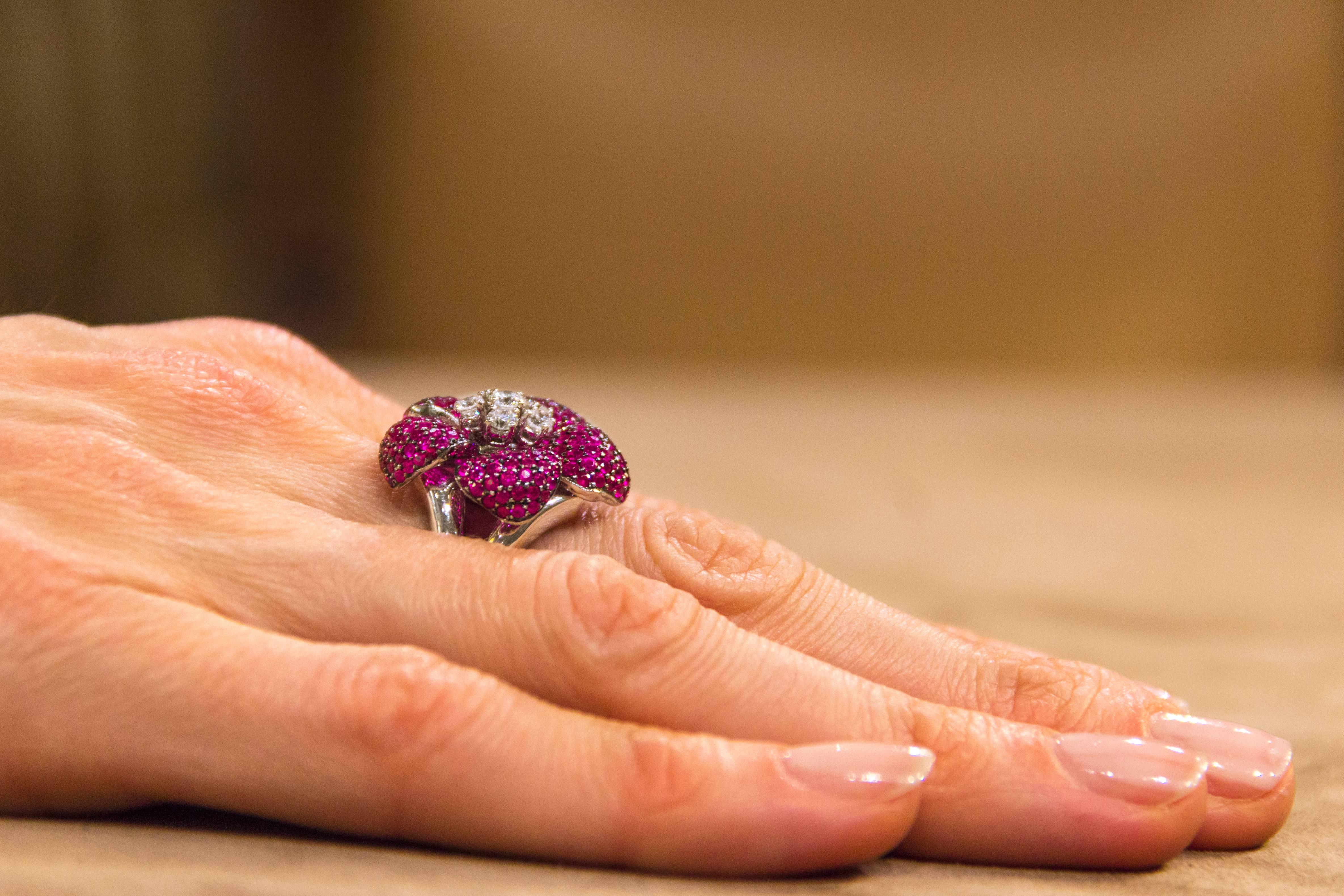 A dazzling flower ring made of 18k white gold with petals encrusted with beautiful ruby pavè with dark rhodium setting, surrounding six prong-set diamonds in the center.
This ring holds 0.61 carats of diamonds and 211 pieces,  3.56 carats of
