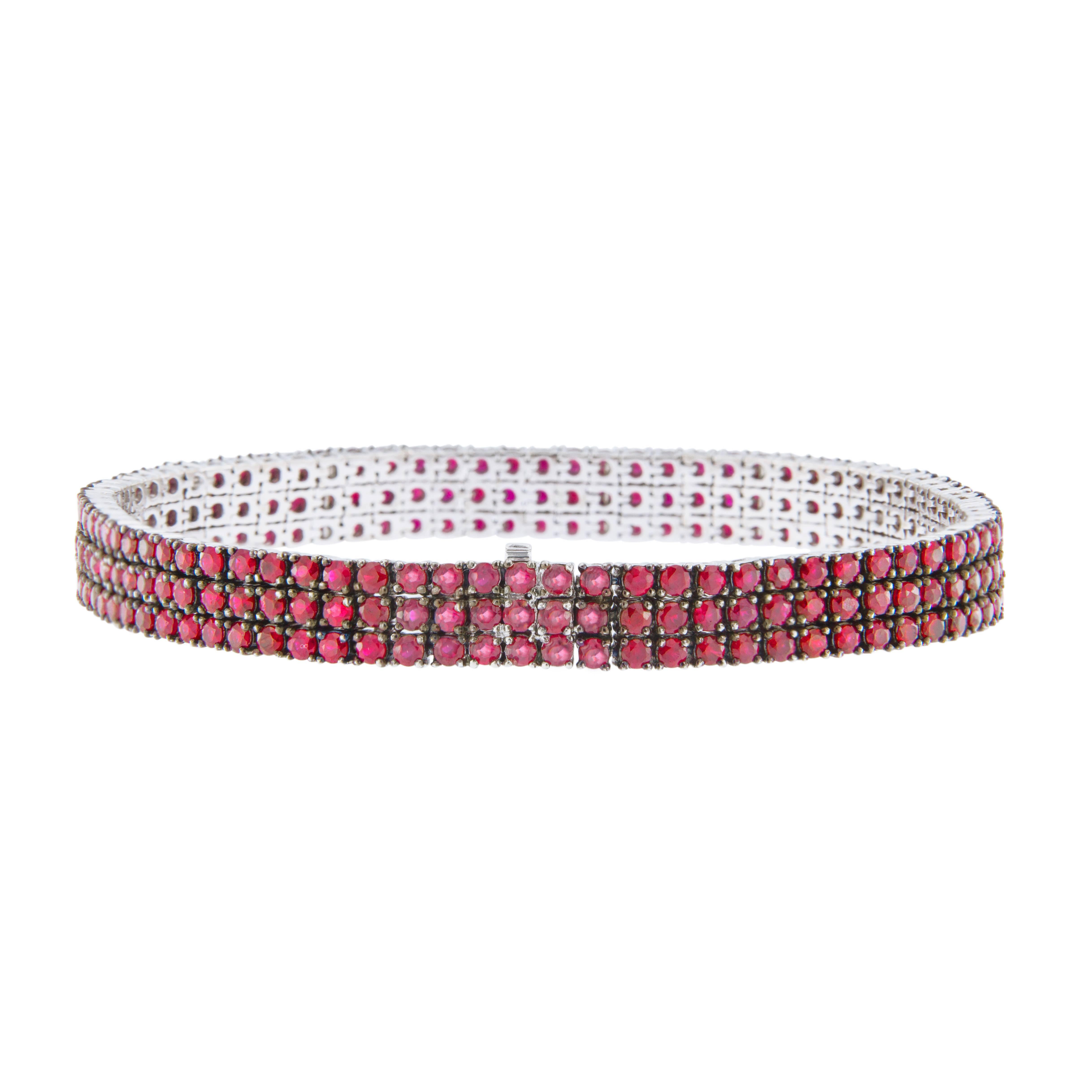 Jona design collection, 18 karat white gold, hand crafted in Italy, three row tennis bracelet set with 9.93 carats of strong, saturated color rubies. 
Dimensions: L x 19 cm, W x 1 cm / L x7.48 in, W x 0.39 in.
All Jona jewelry is new and has never
