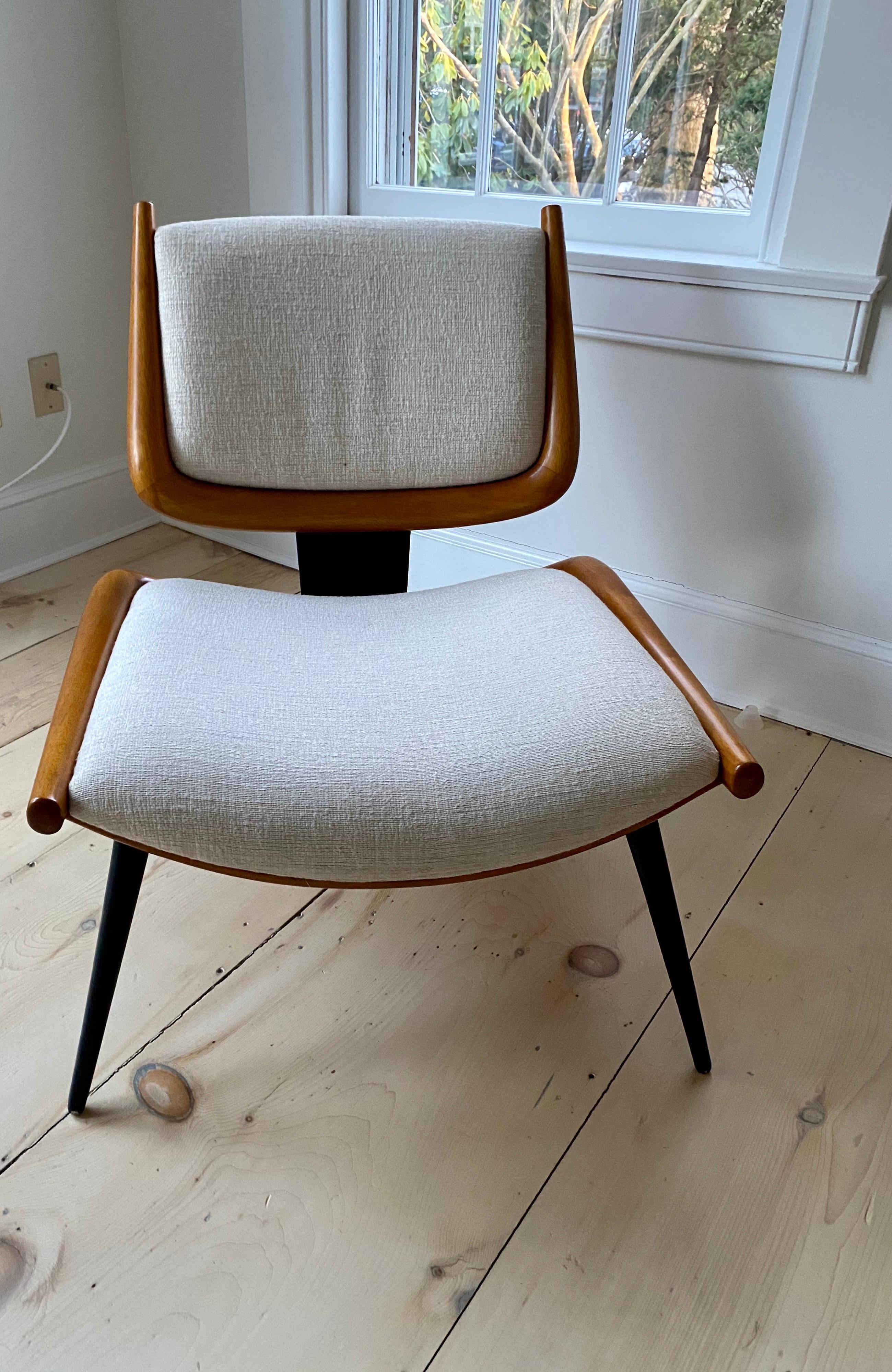 No longer being produced, this chair by Jonathan Adler has elements of midcentury European design but has proportions that do not compromise comfort. It is crafted from wood, sanded and oiled to reveal its natural beauty, joined to a blackened steel
